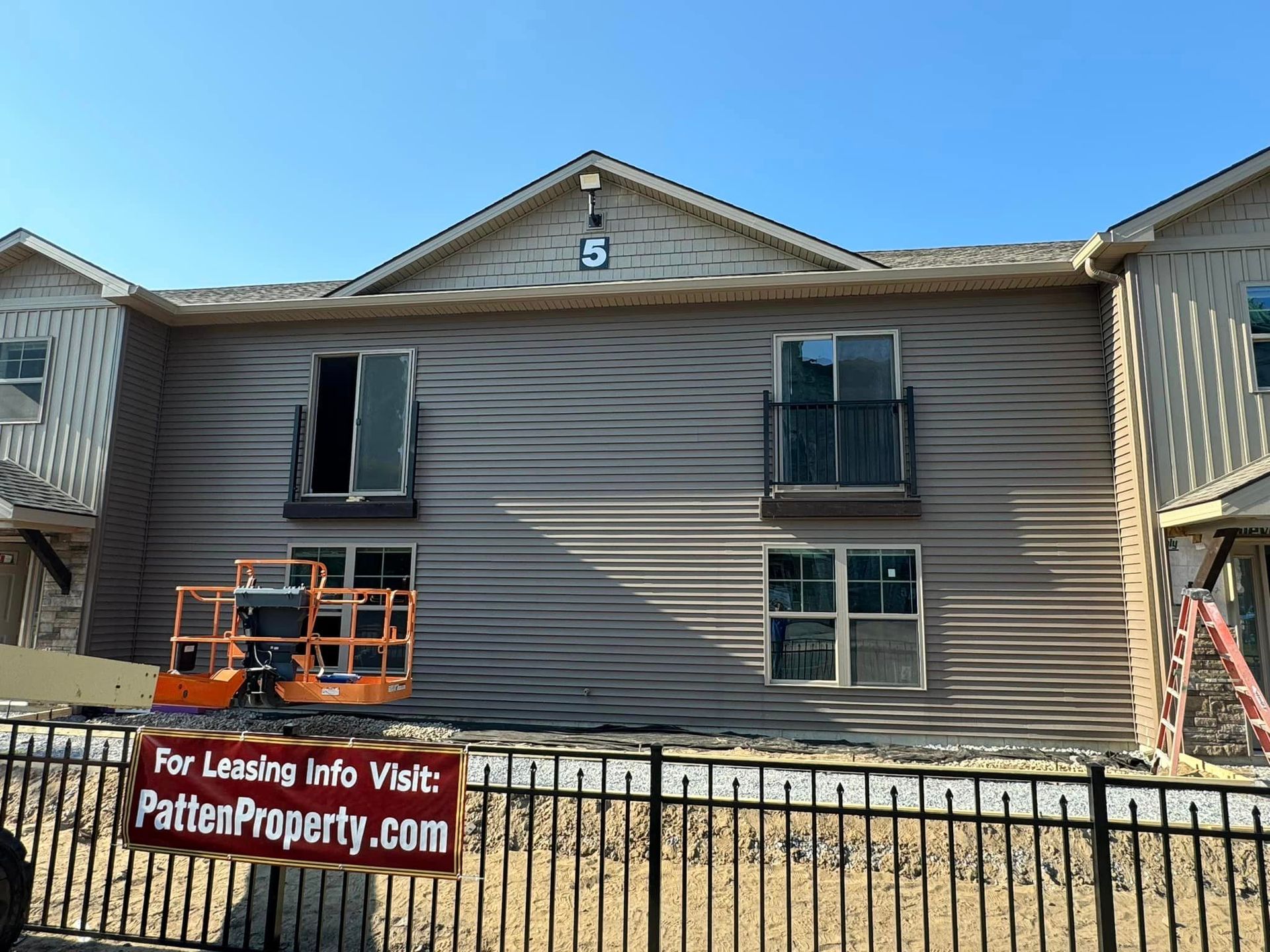 A building with a sign about leasing info in front of it