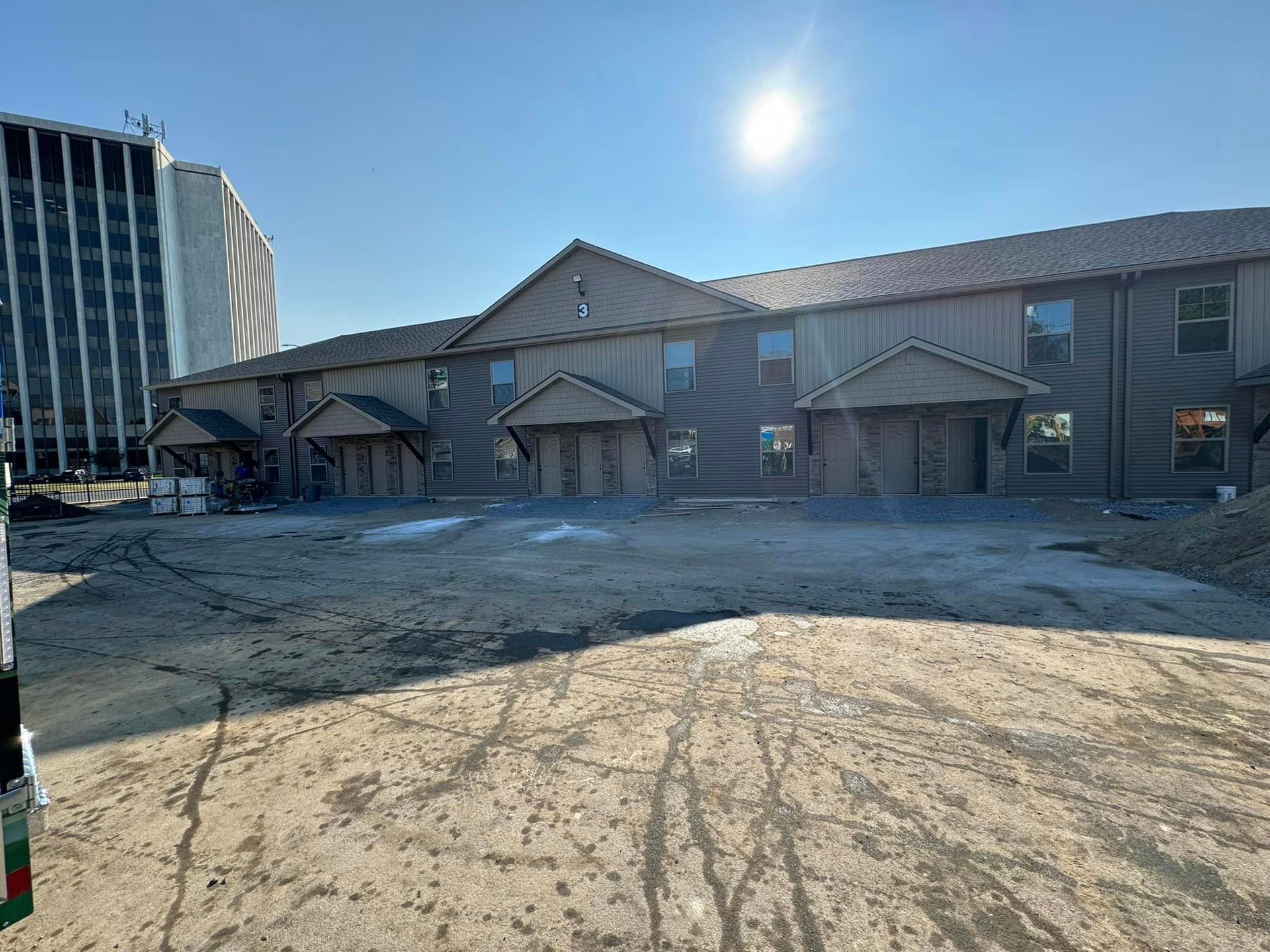 A large building with a lot of windows and a lot of dirt in front of it