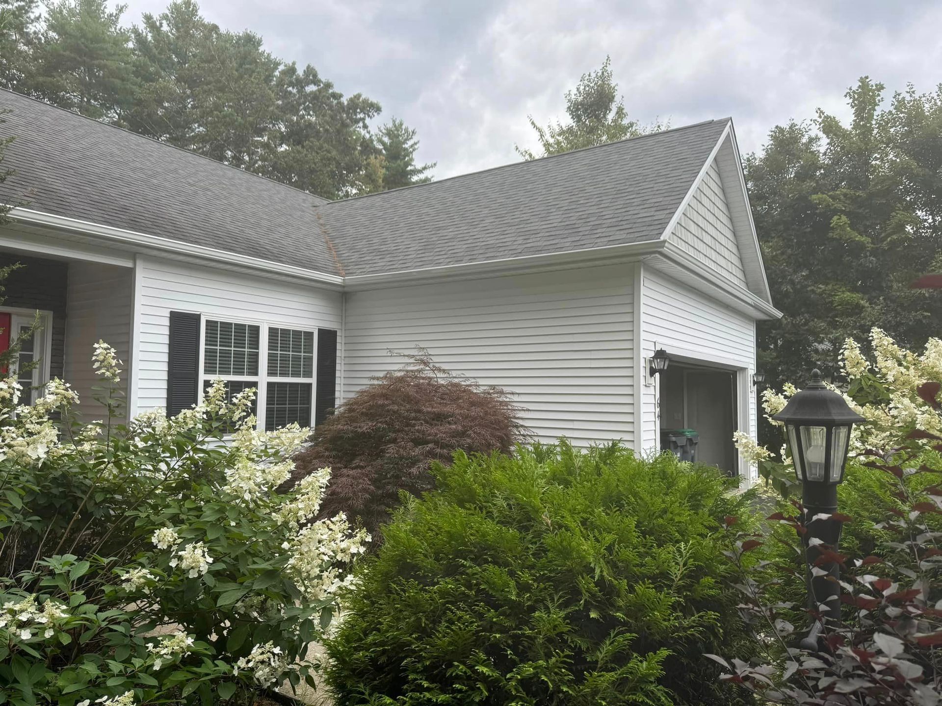 A white house with a gray roof and black shutters