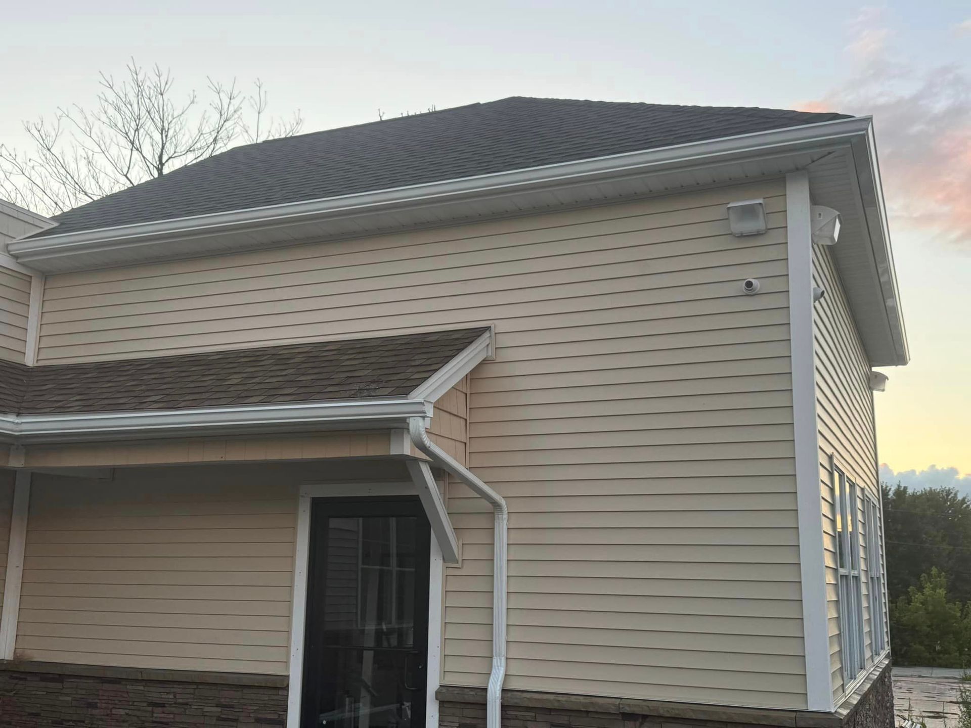 A white house with a black roof and a porch