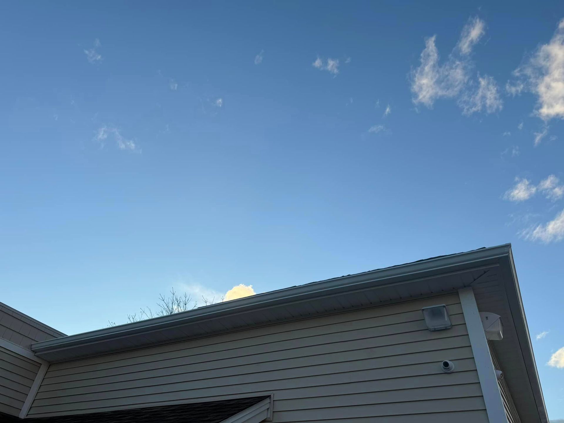 A house with a blue sky and clouds behind it
