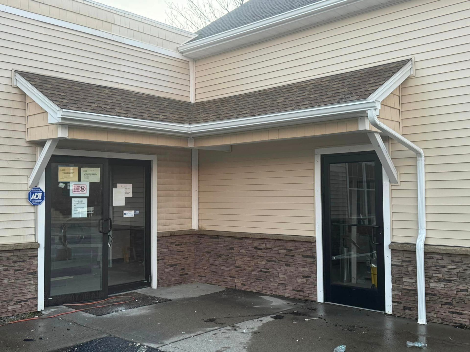 The front of a building with a roof and two doors