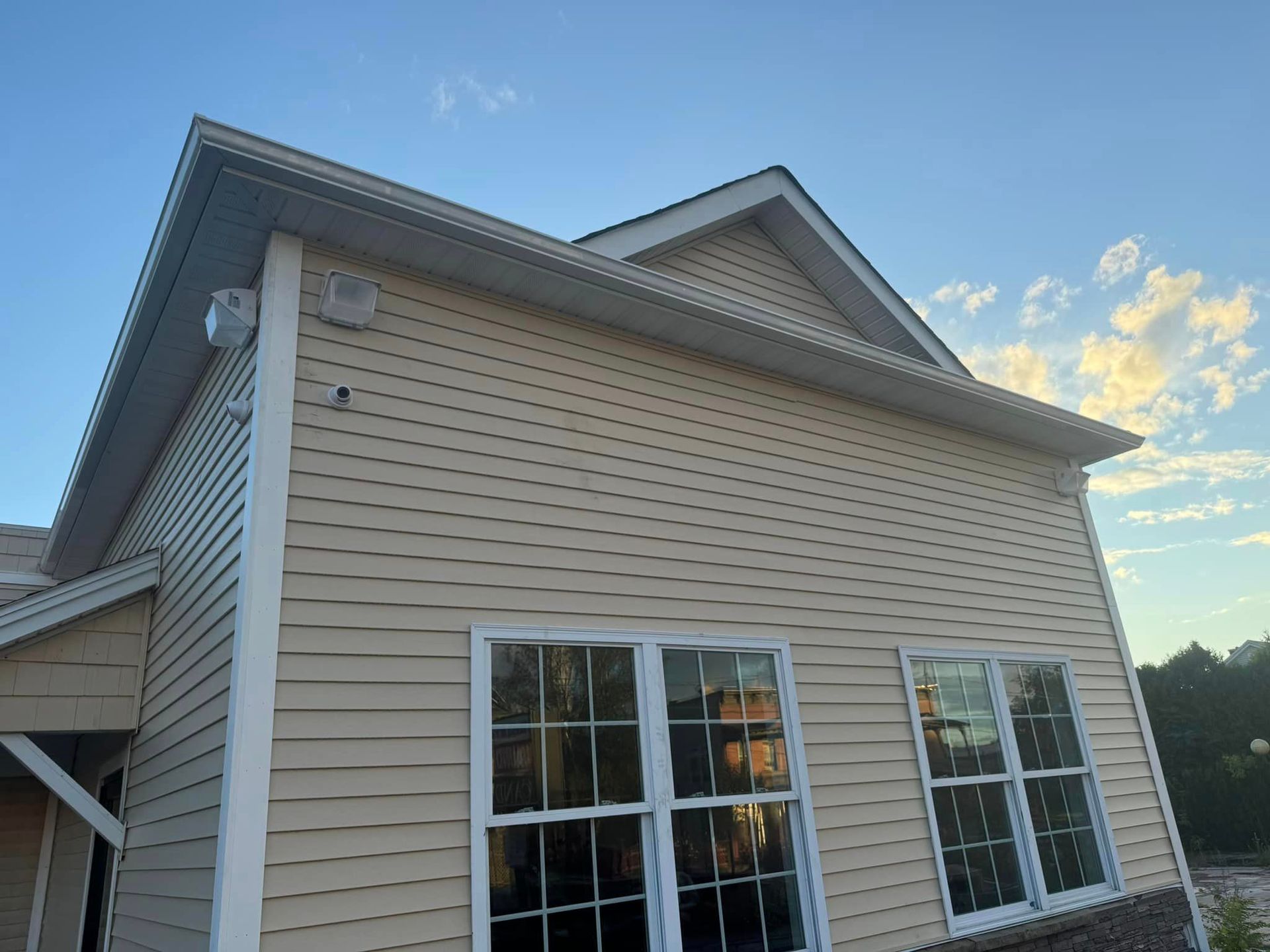 A house with a lot of windows and a blue sky in the background