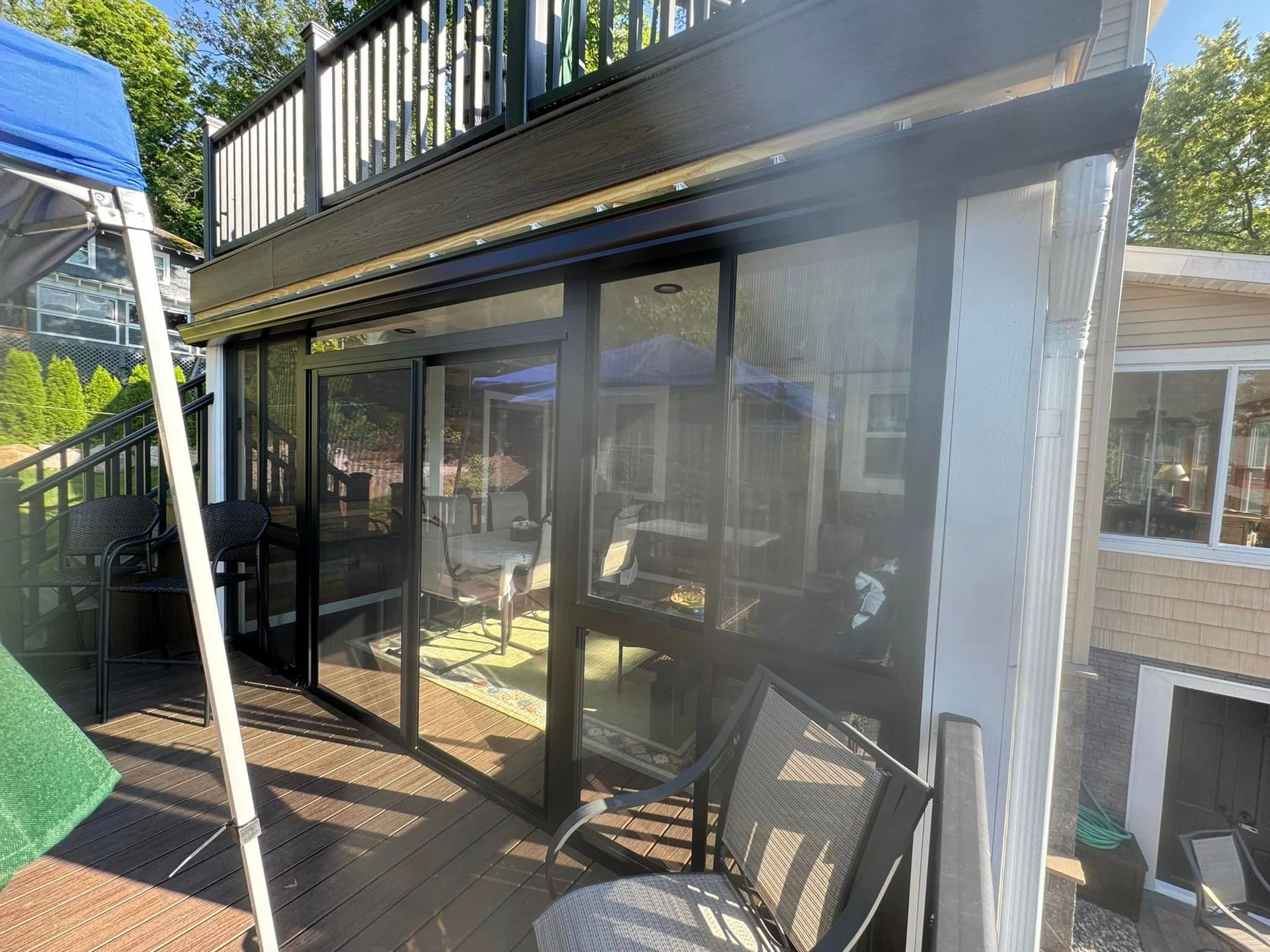 A patio with sliding glass doors and a blue canopy