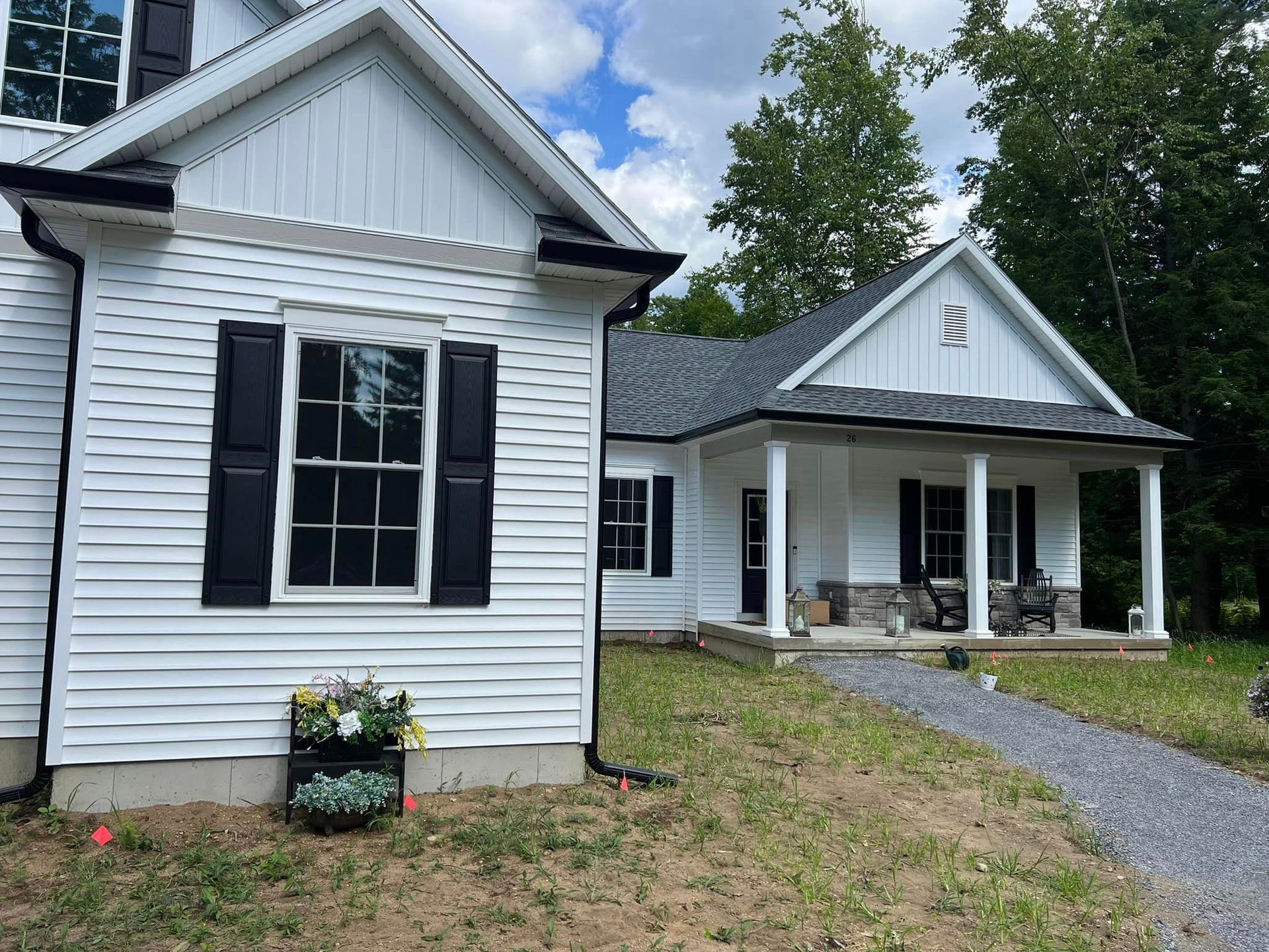 A white house with black shutters and a porch