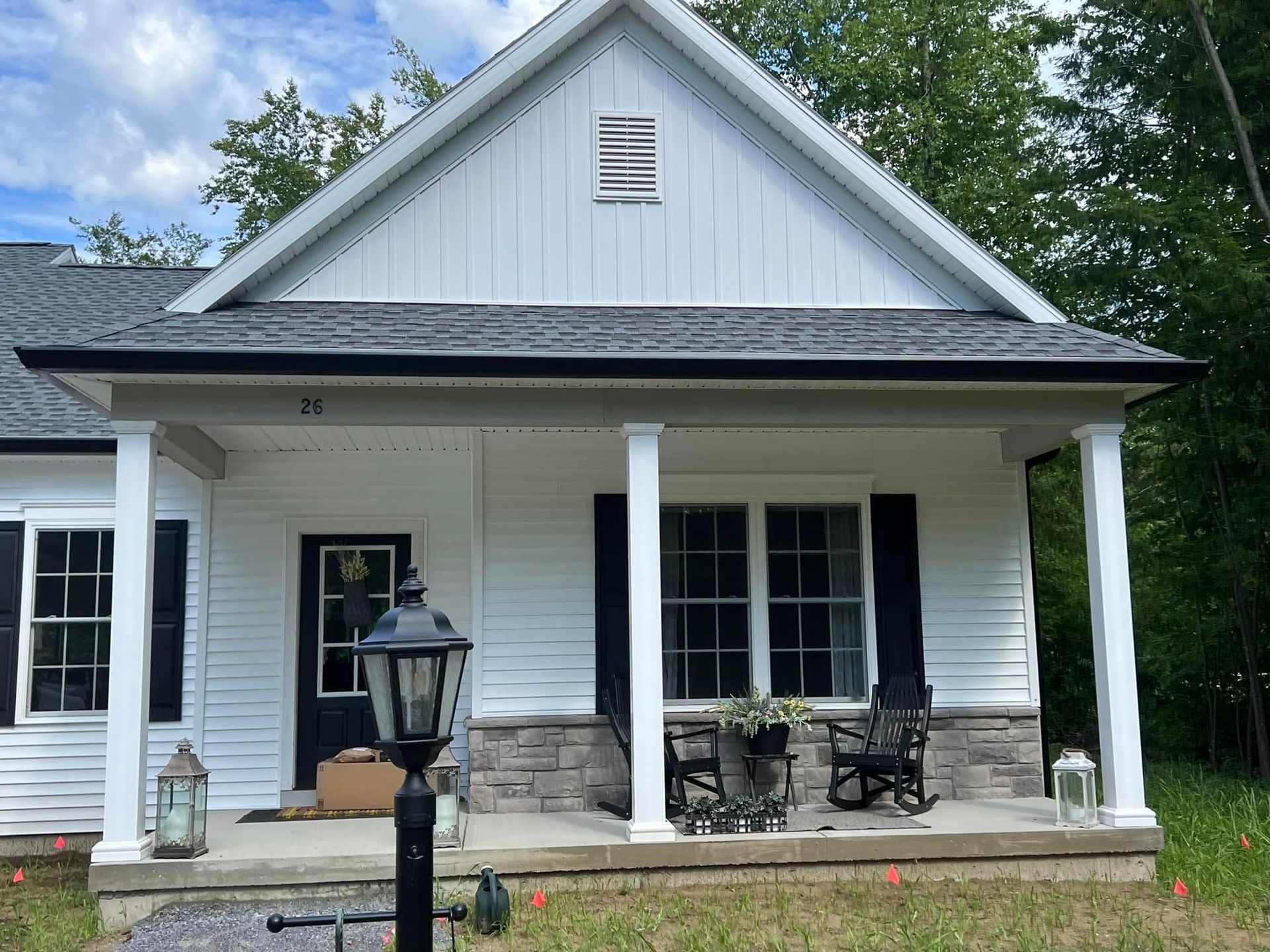 A white house with black shutters and a porch