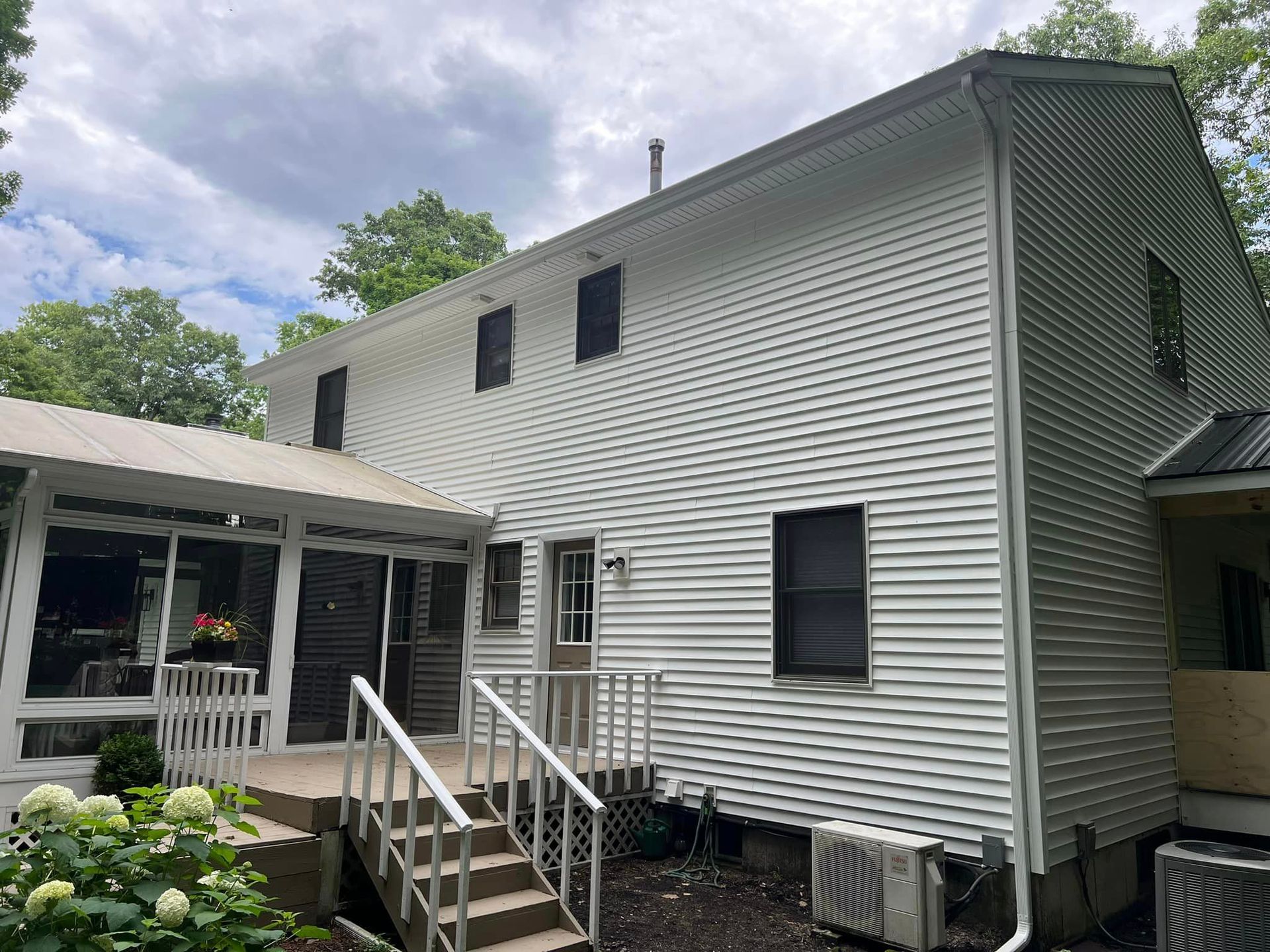 The back of a white house with stairs leading up to it