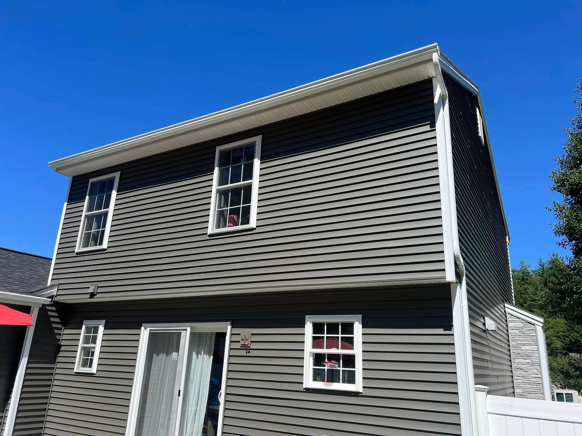 A house with a lot of windows and a blue sky in the background