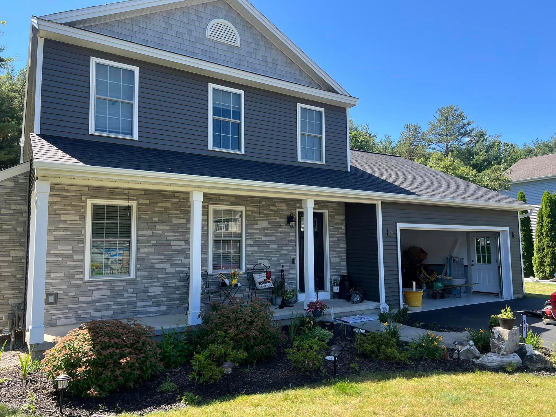 A large brick house with a large porch and a garage