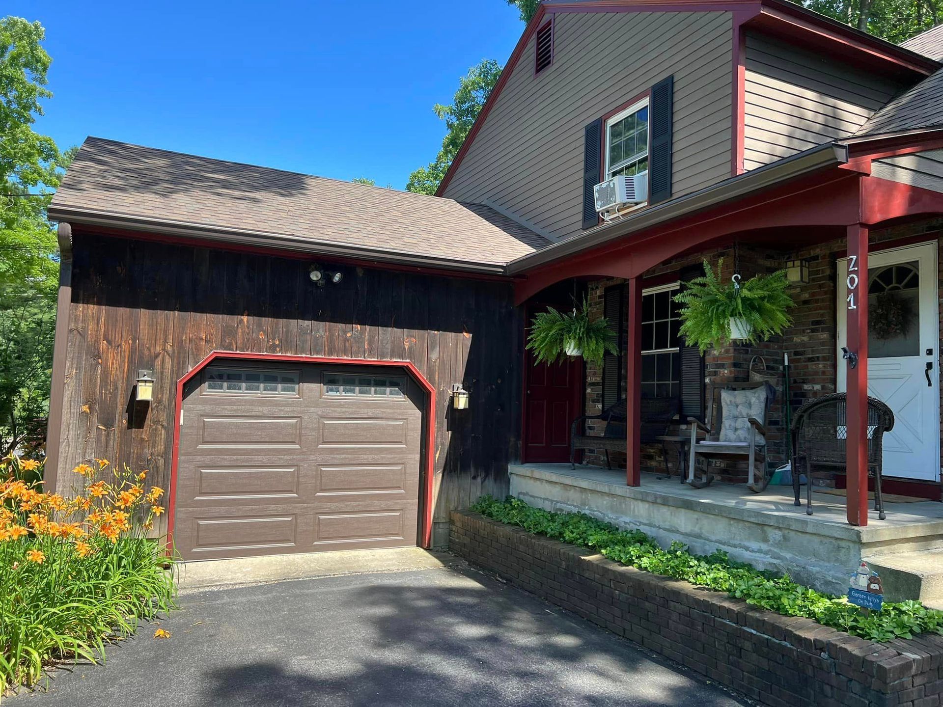 A house with a garage and a porch on a sunny day