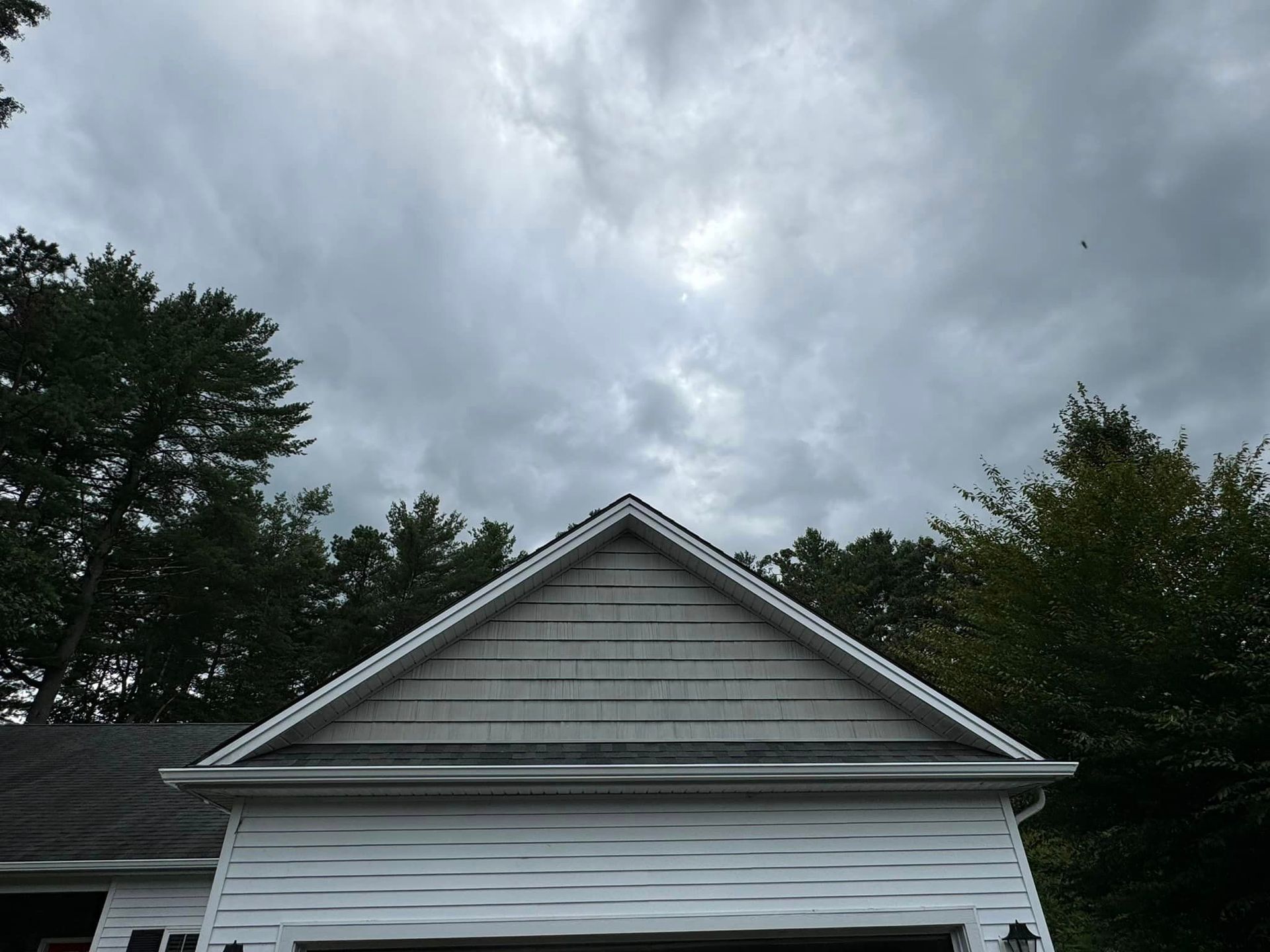 A white garage with a cloudy sky in the background