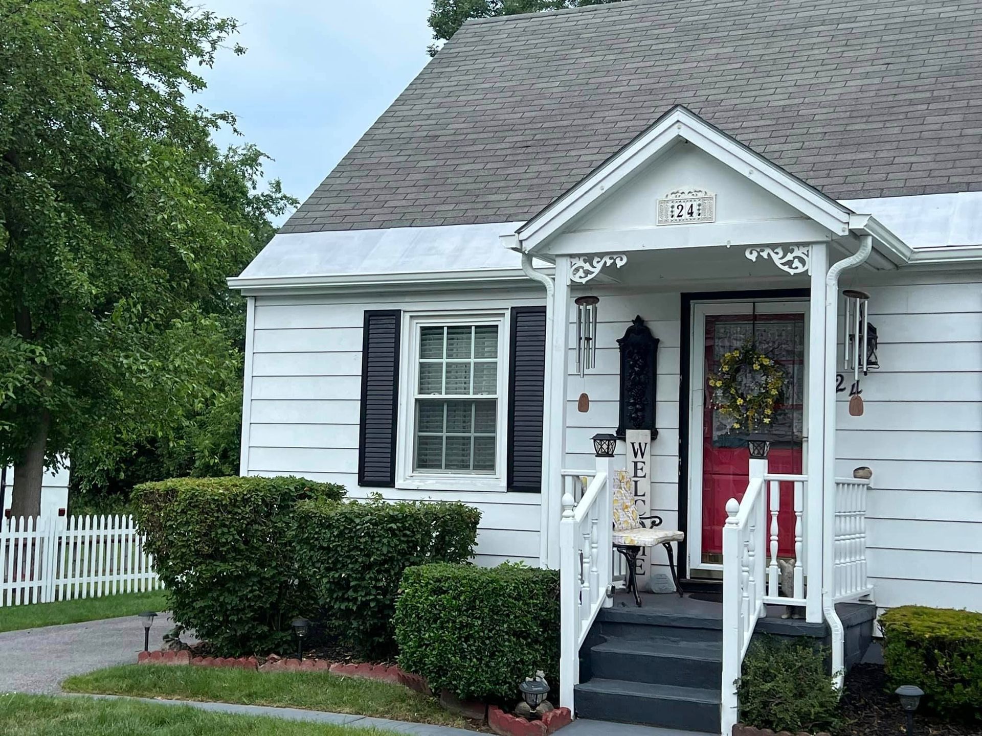 A white house with black shutters and a red door