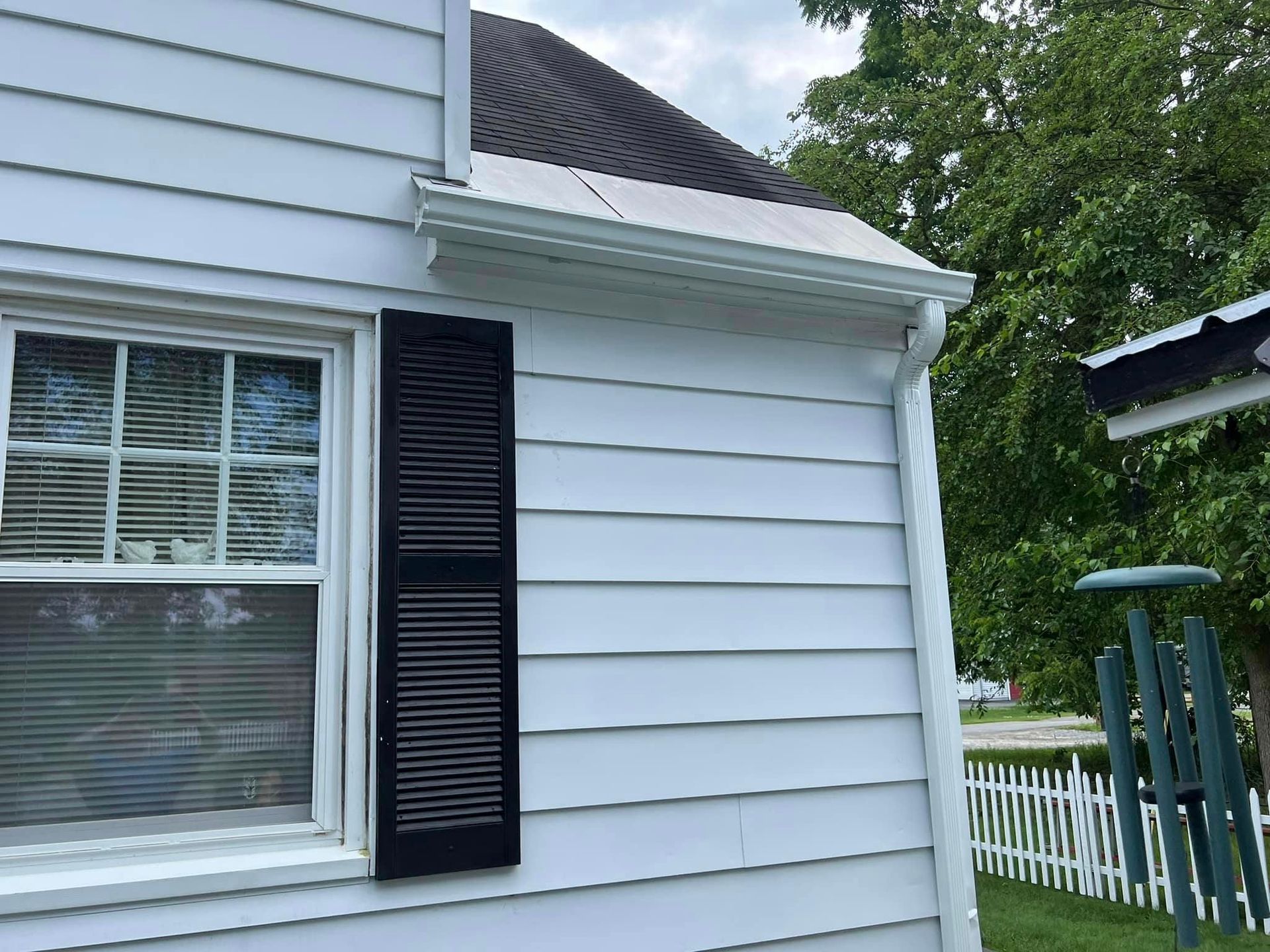 A white house with black shutters and a window