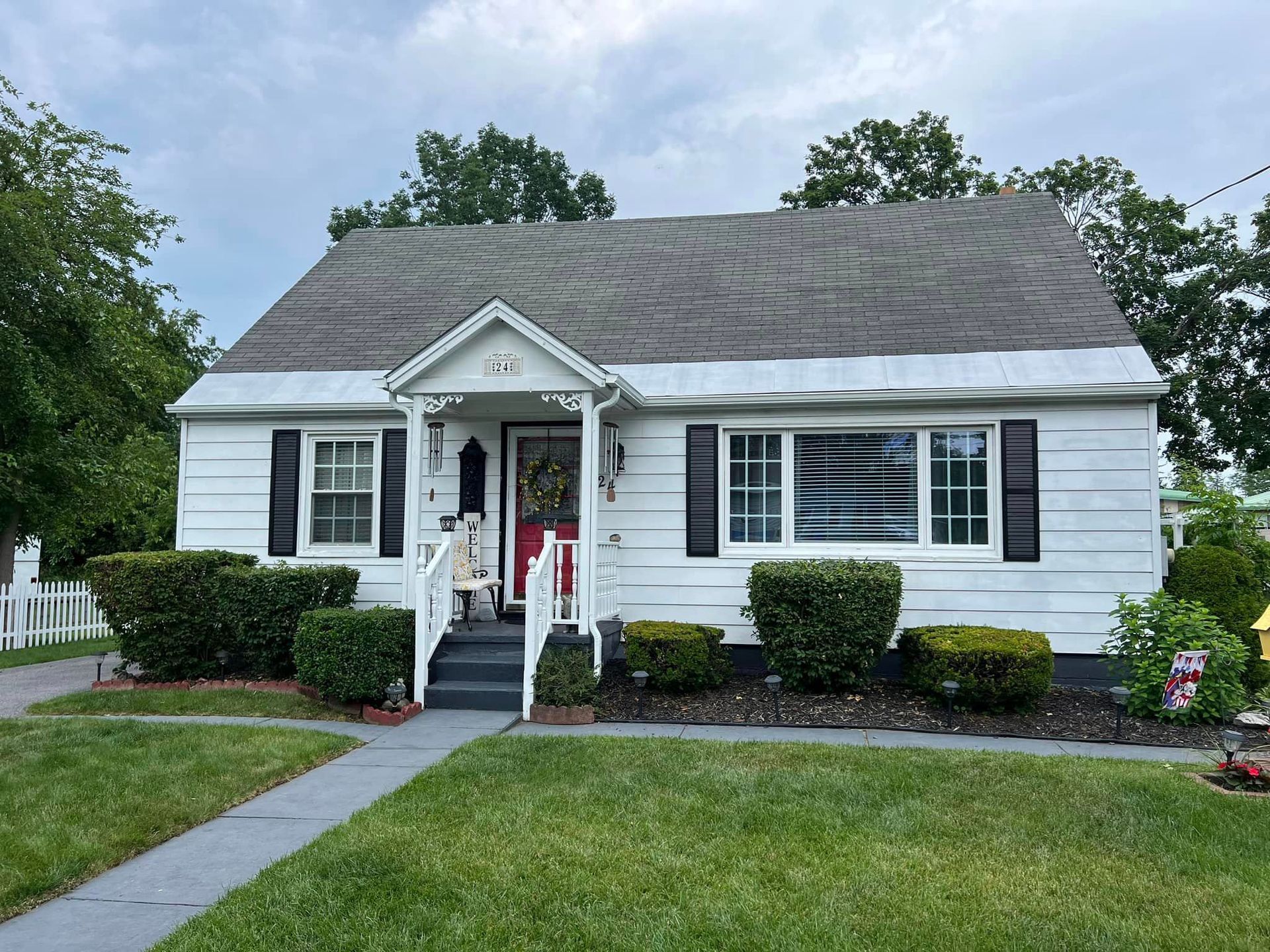 A white house with a gray roof and black shutters