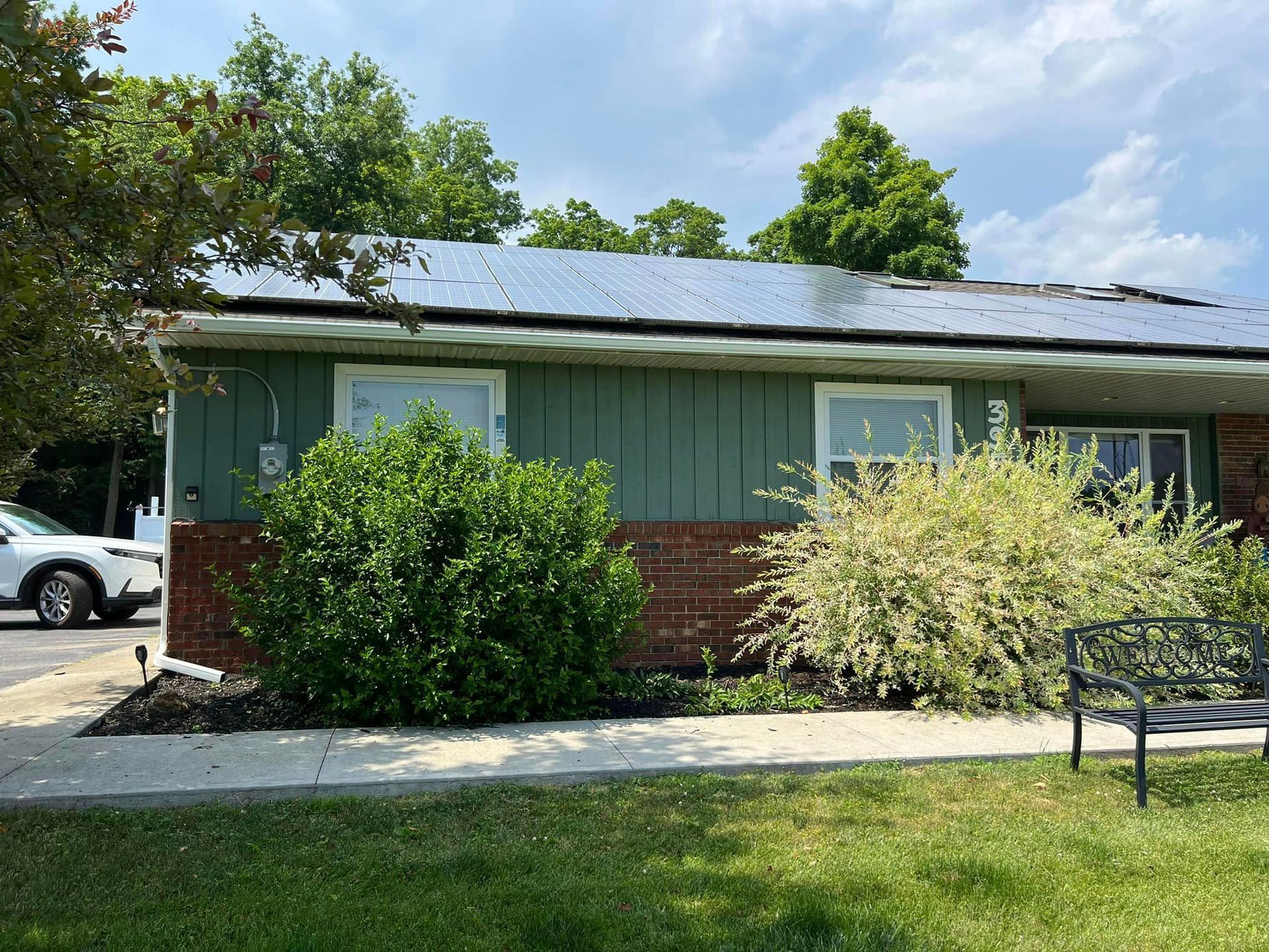 A green house with solar panels on the roof