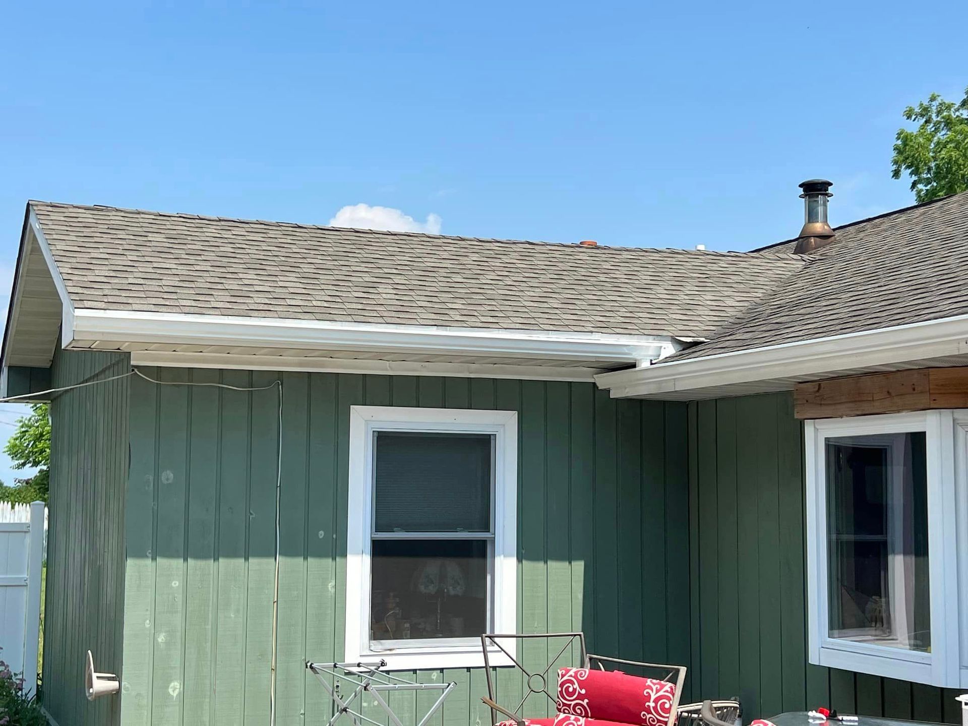 A green house with a red chair in front of it