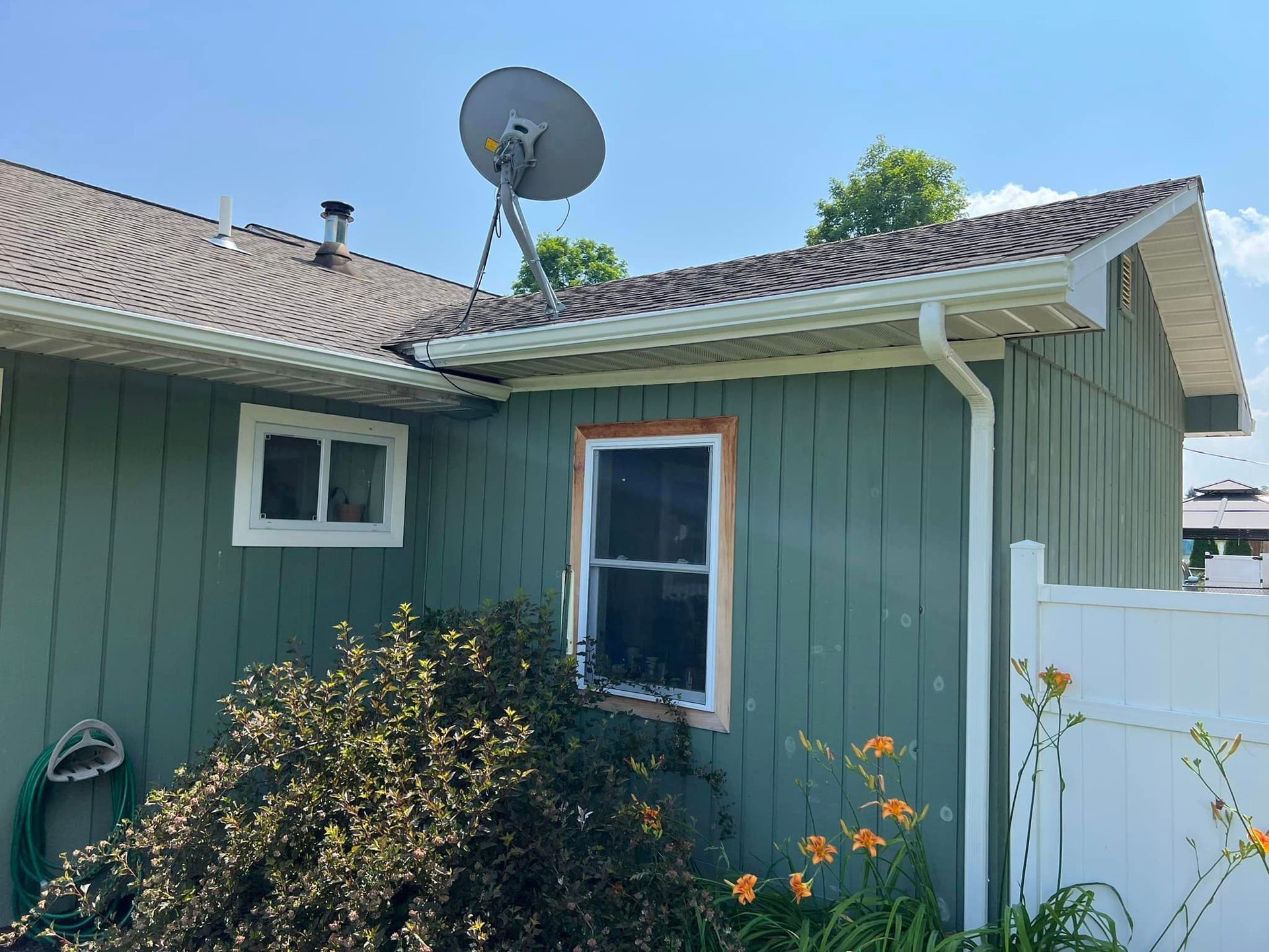 A green house with a satellite dish on the roof
