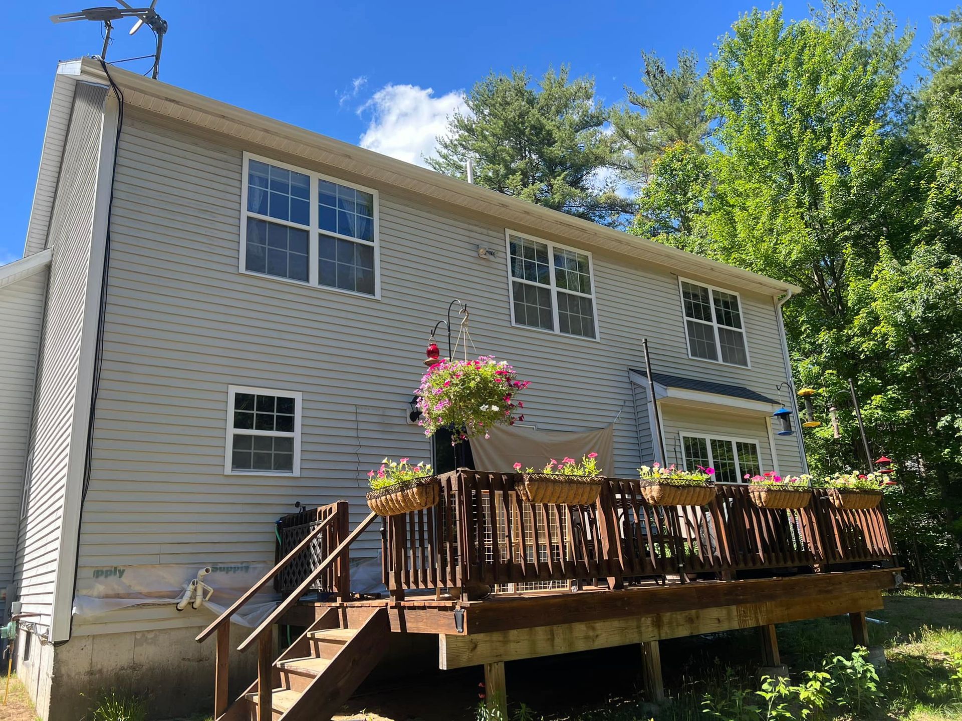 The back of a house with a large deck and stairs leading up to it