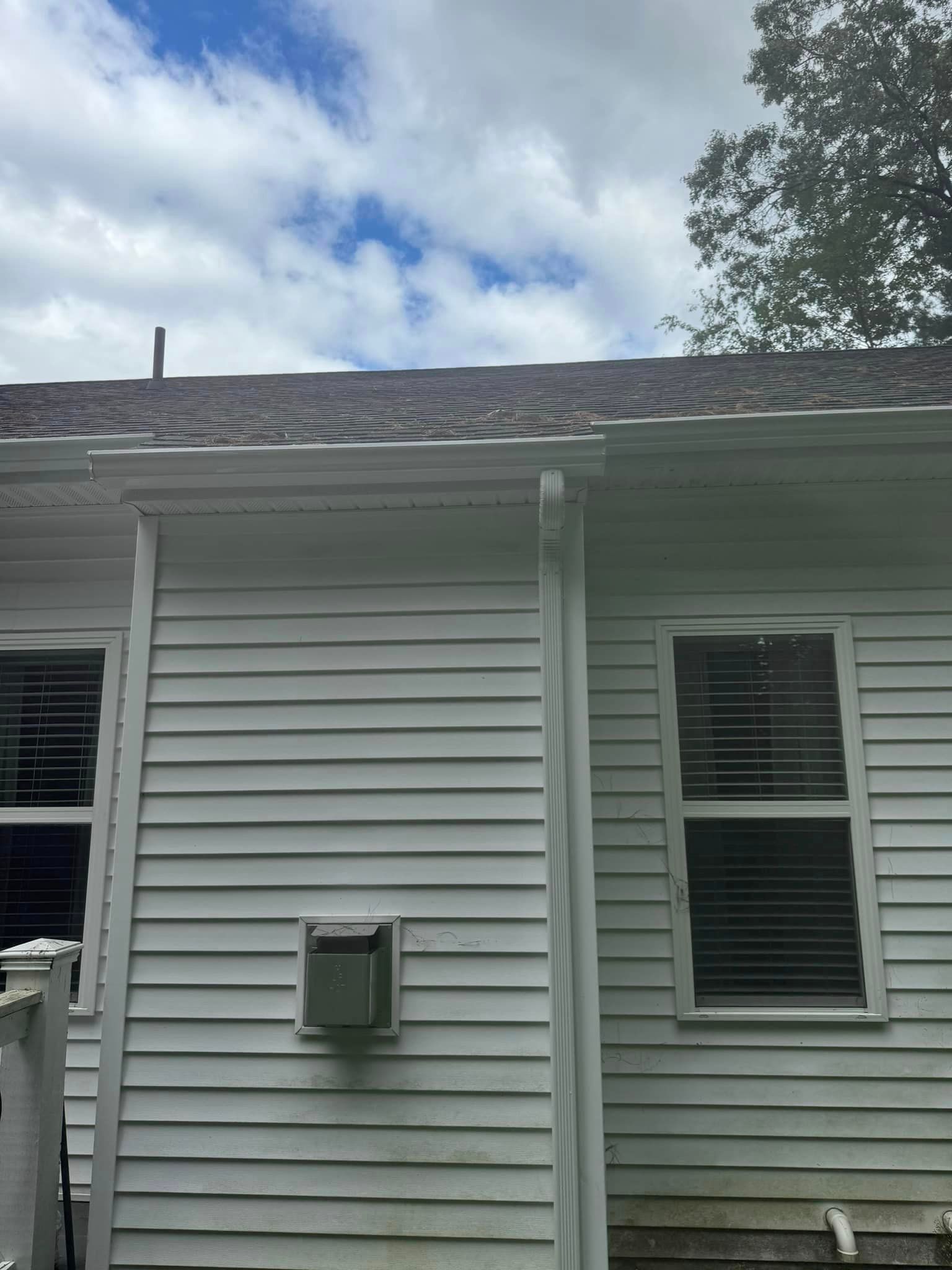 The back of a white house with a roof and windows