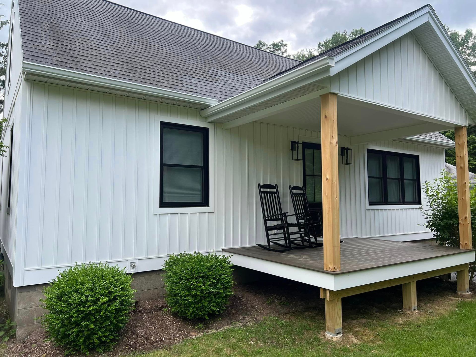A white house with a porch and rocking chairs on it