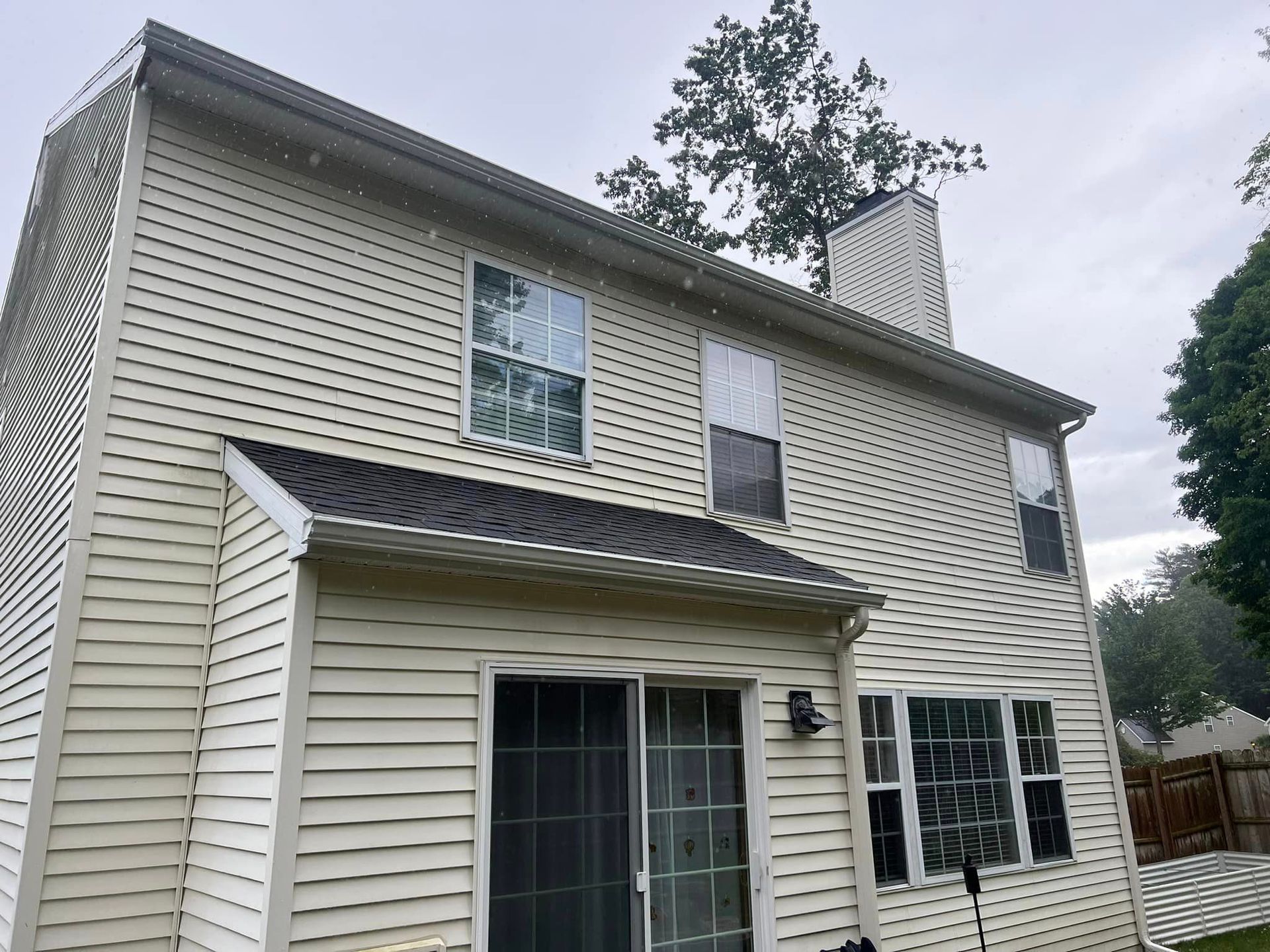 The back of a house with a sliding glass door and a chimney
