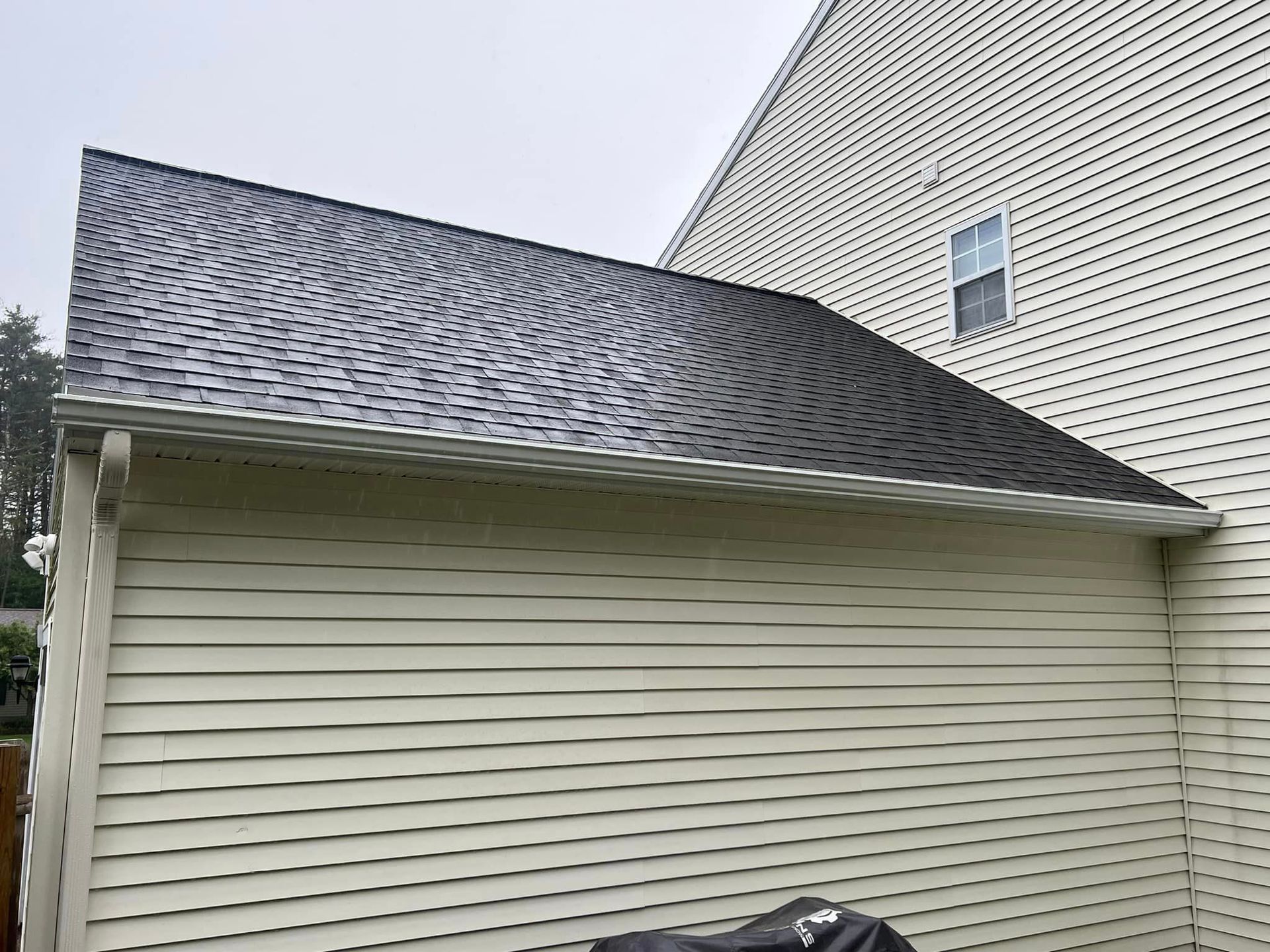 A white house with a black roof and a motorcycle parked in front of it