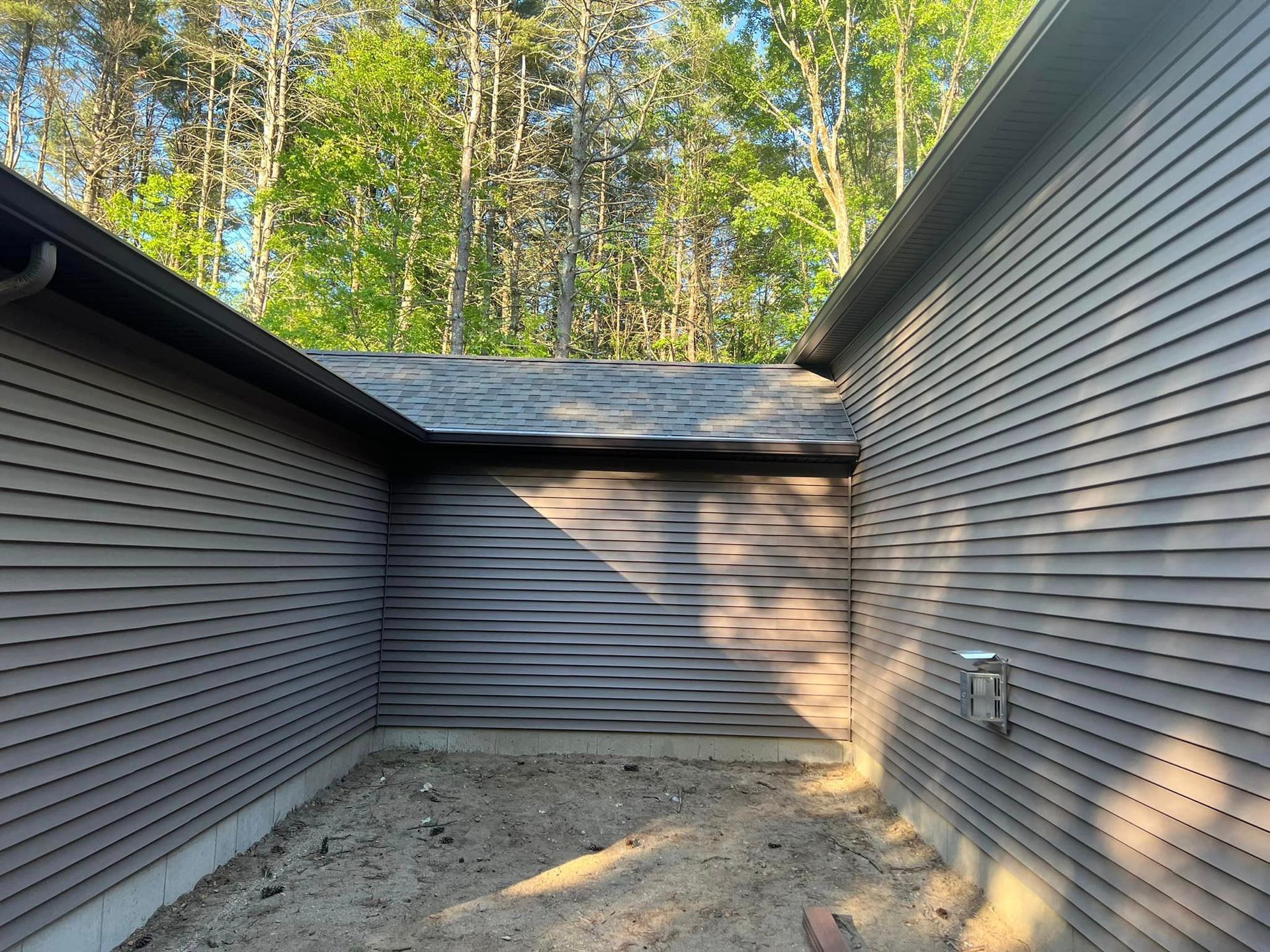 There is a shadow of a tree on the side of a building