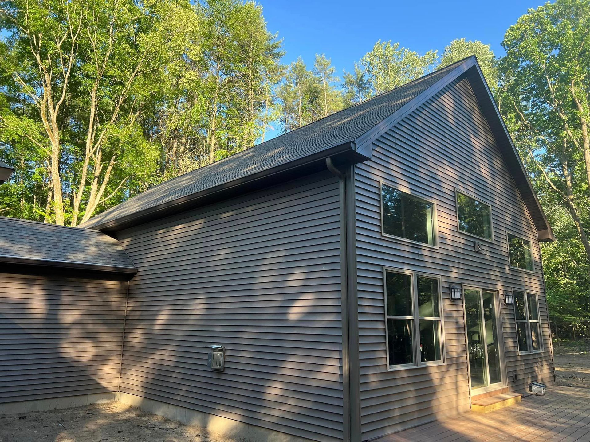 A large house with a lot of windows is surrounded by trees