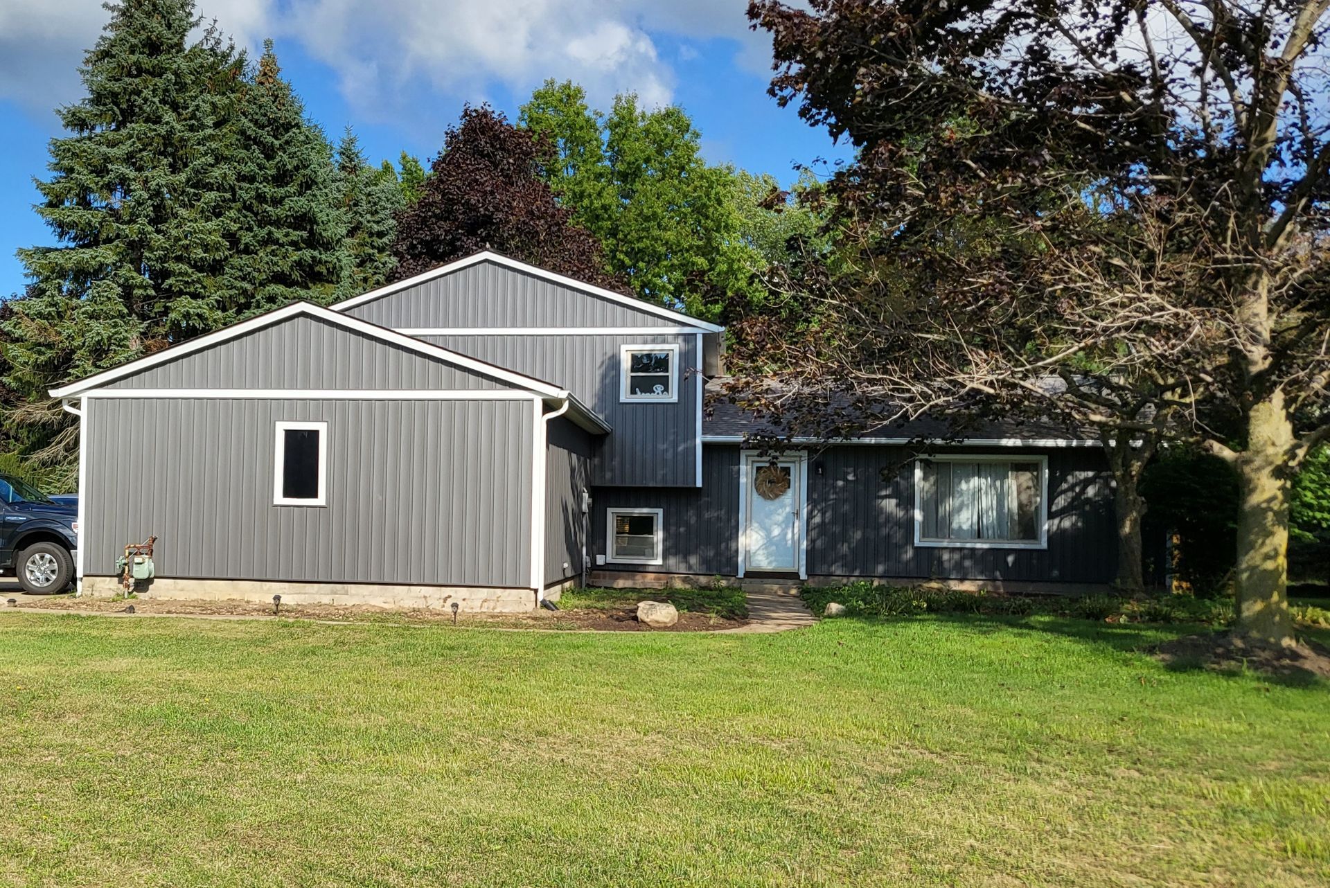 Gray house with white trim and a green lawn.