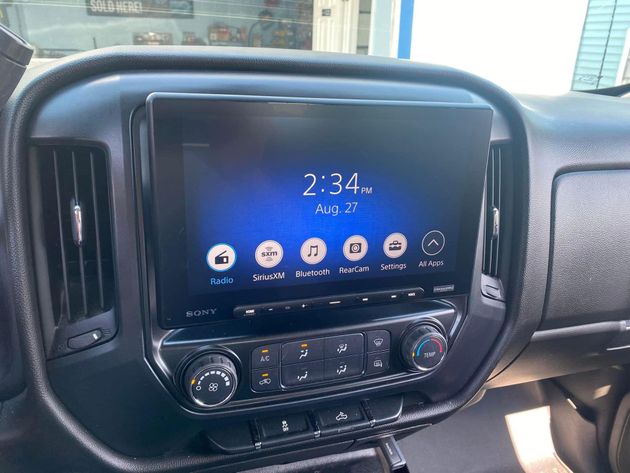 Car dashboard with a touchscreen infotainment display showing 2:34 and app icons, above climate controls.