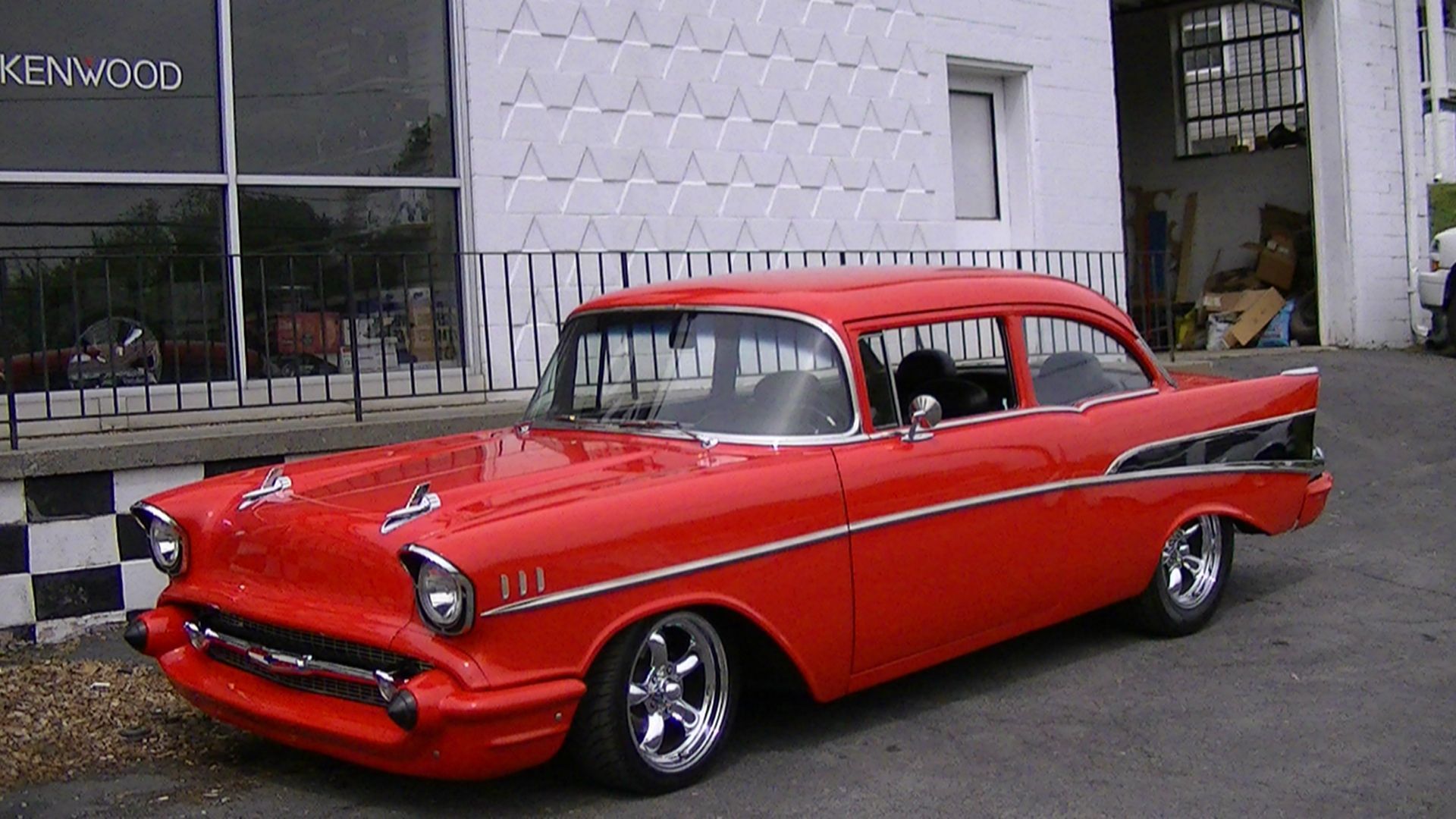 Red classic car parked on a street outside a building