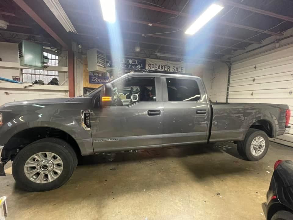 Gray pickup truck parked inside a garage under fluorescent lights