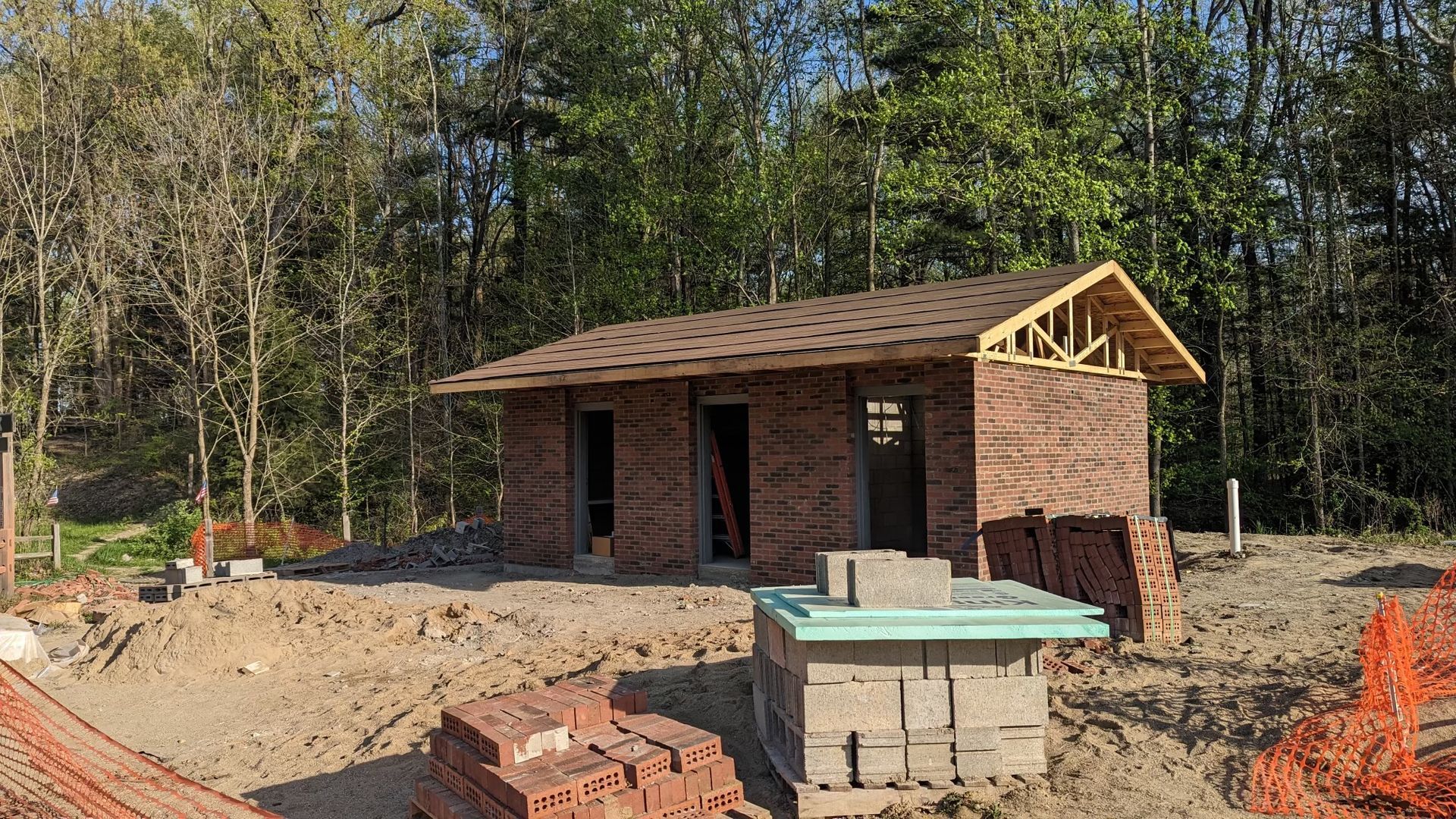 A brick building is being built in the middle of a forest.