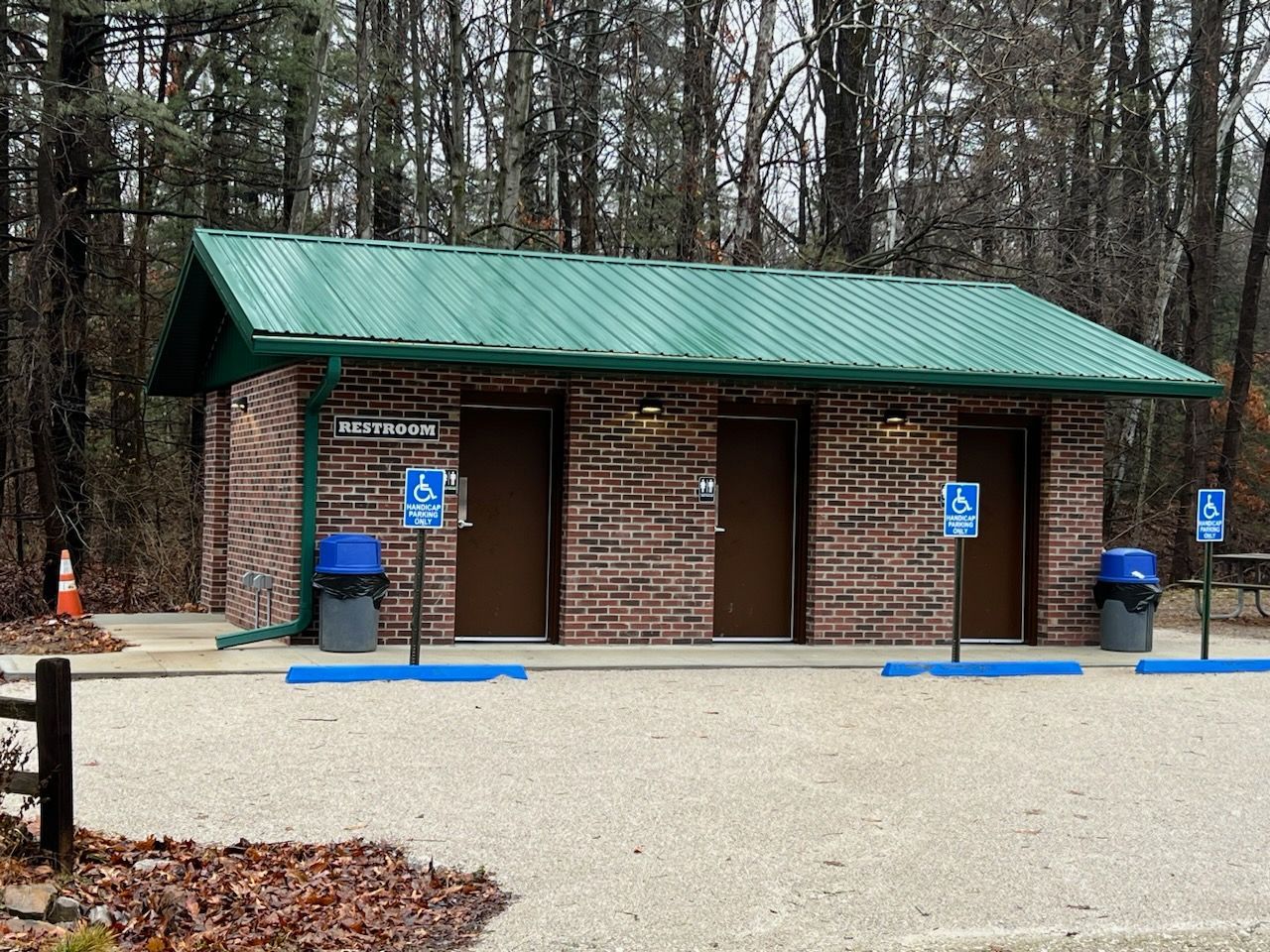 A brick building with a green roof and handicapped signs