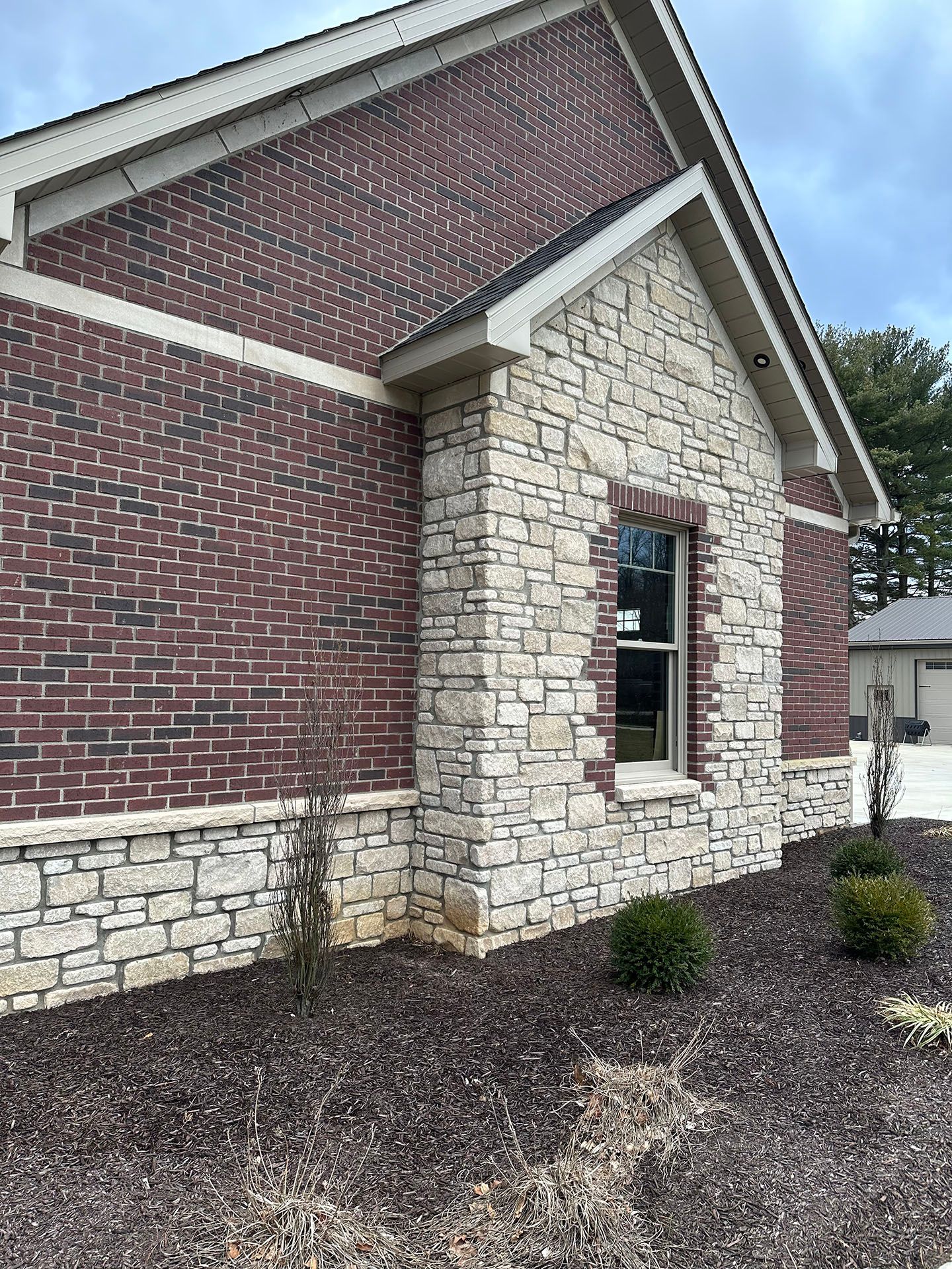 A brick and stone building with a window on the side.