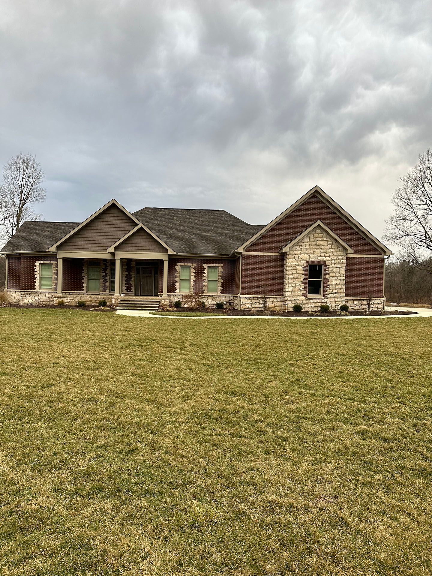 A large house is sitting on top of a lush green field.