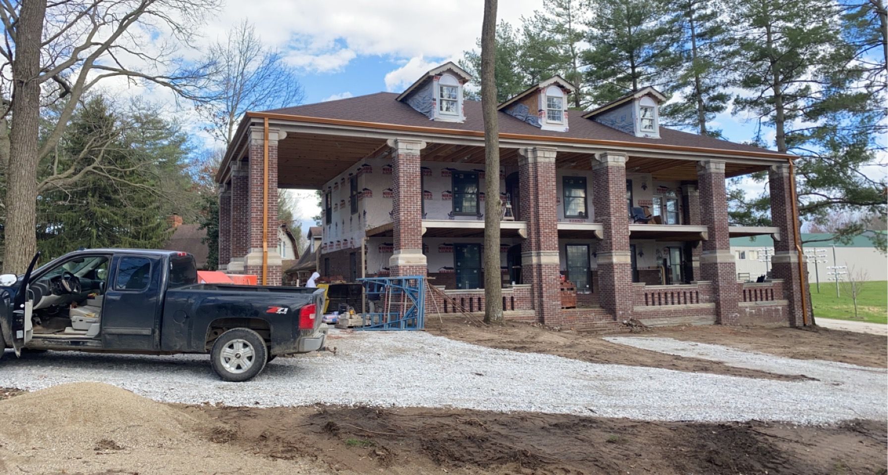 A truck is parked in front of a house under construction.