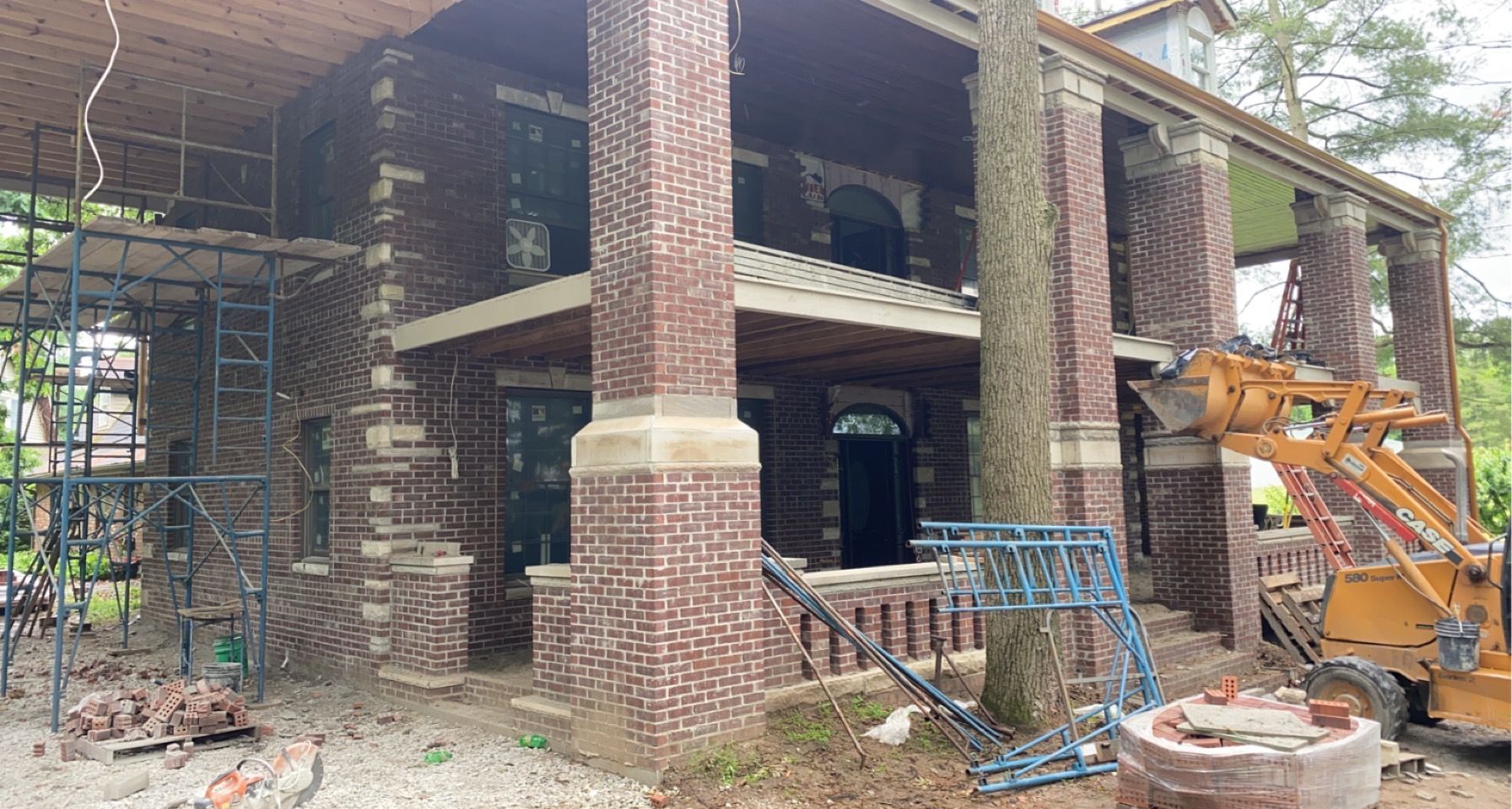 A large brick house is being built with scaffolding around it.