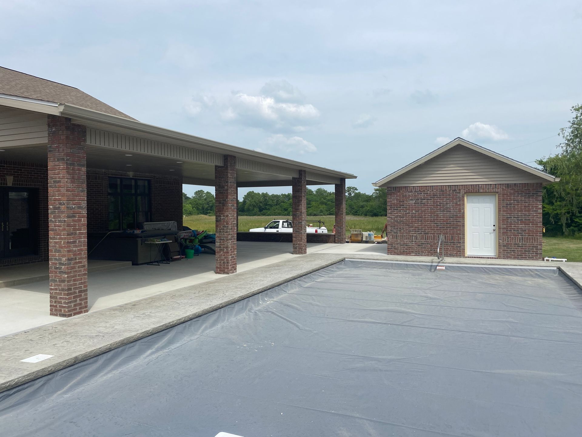 There is a large swimming pool in the backyard of a house.