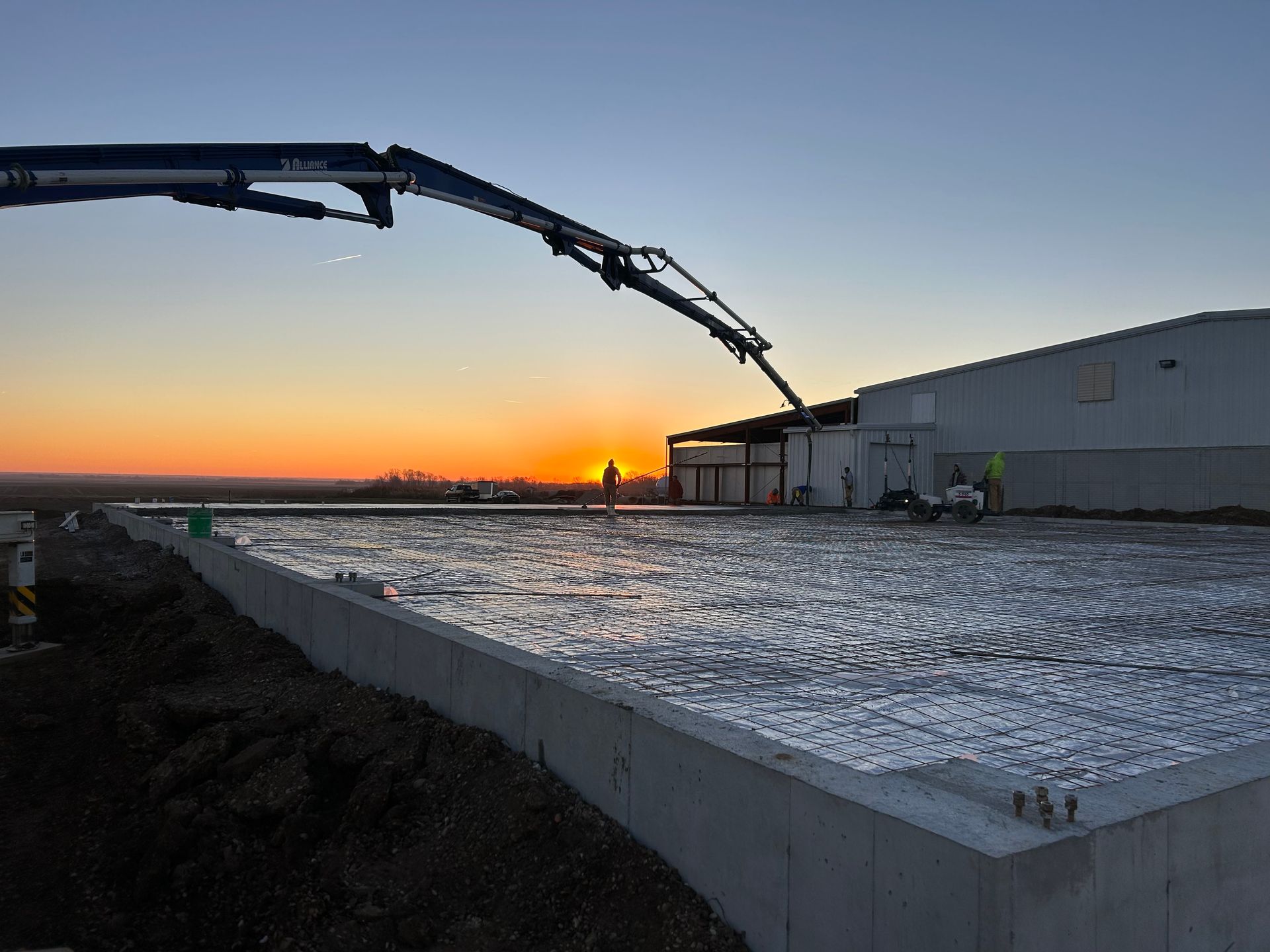 A construction site with a sunset in the background