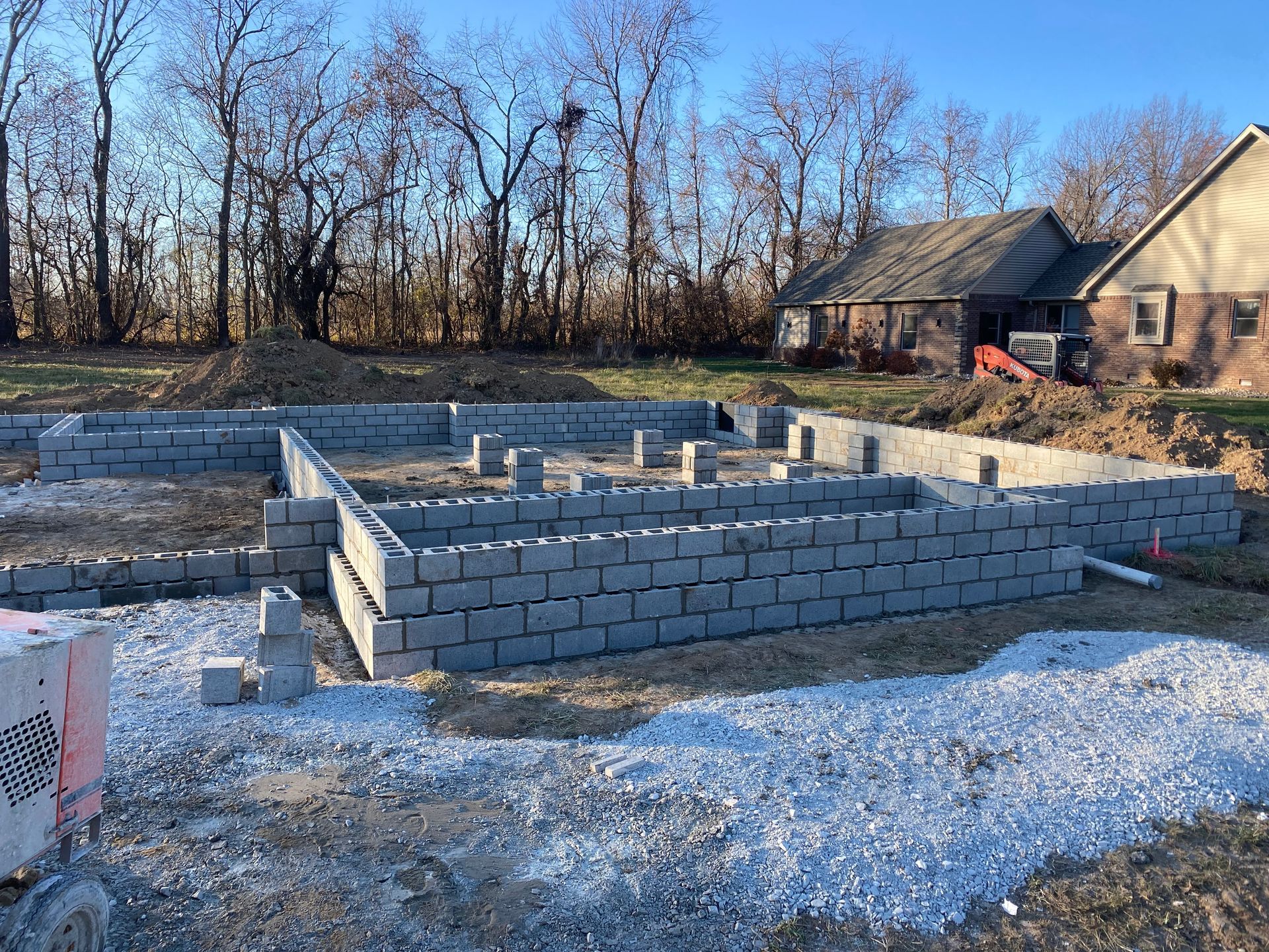 A brick foundation is being built in front of a house.