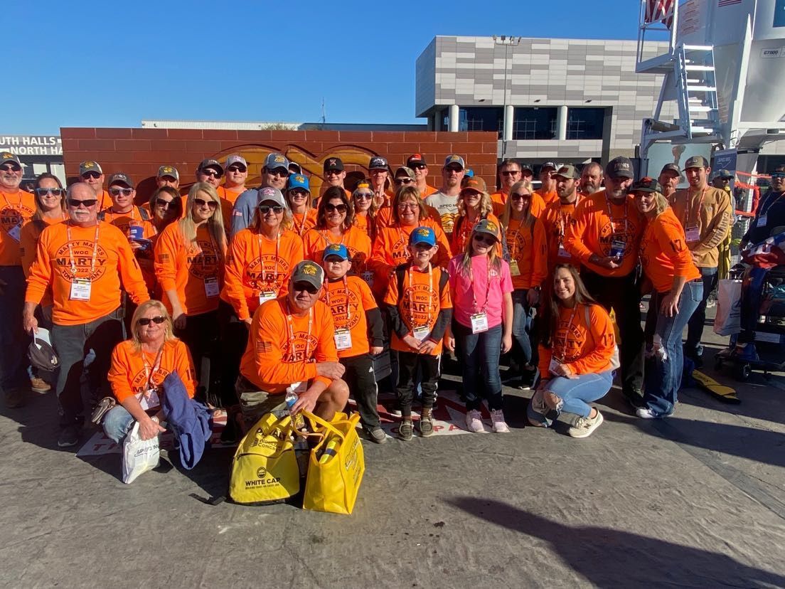 A large group of people wearing orange shirts are posing for a picture.