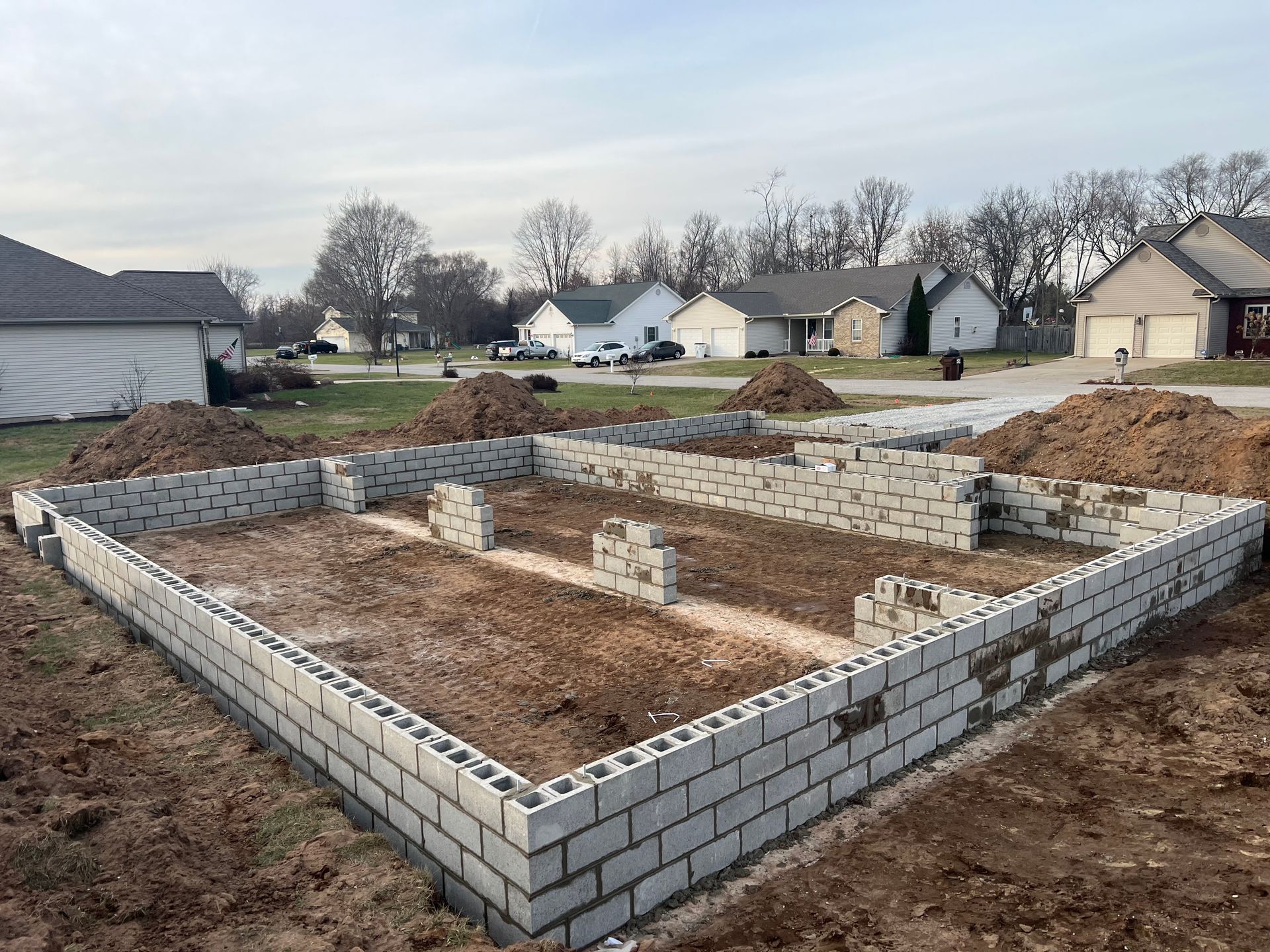 The foundation of a house is being built in a residential area.