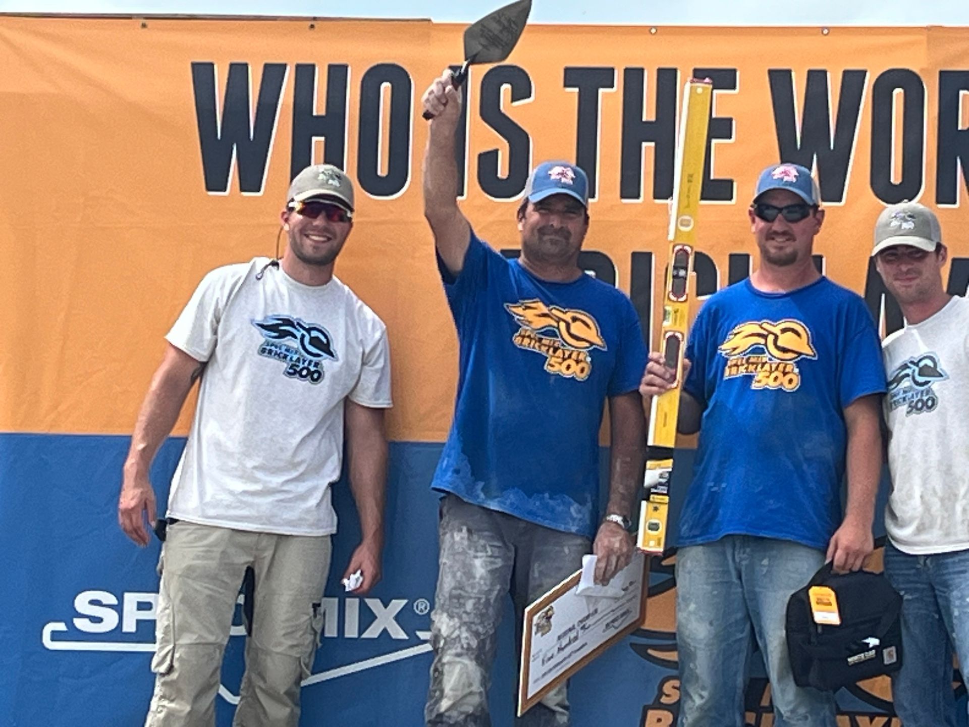 A group of men standing in front of a sign that says who is the world