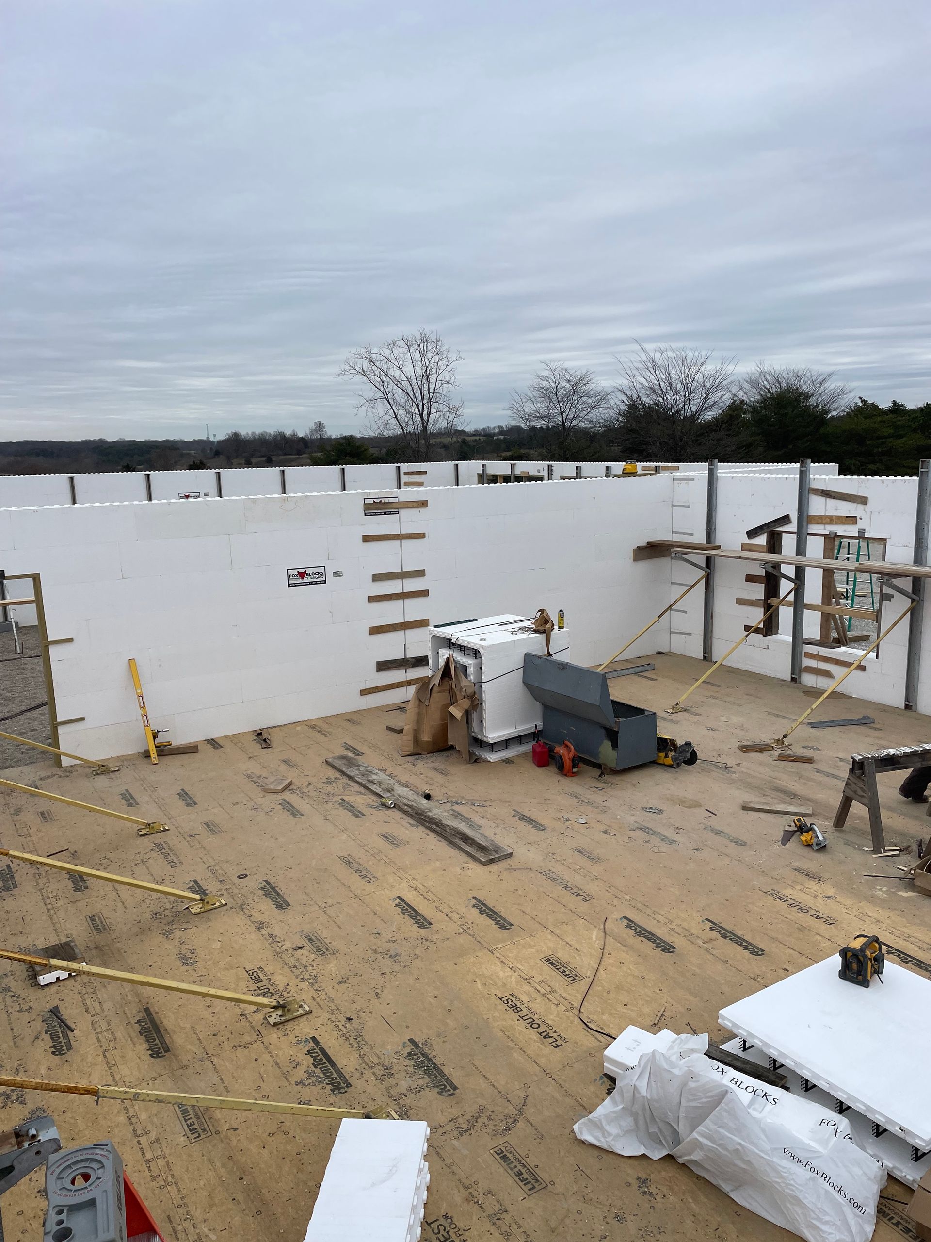 A large white wall is being built on a construction site.