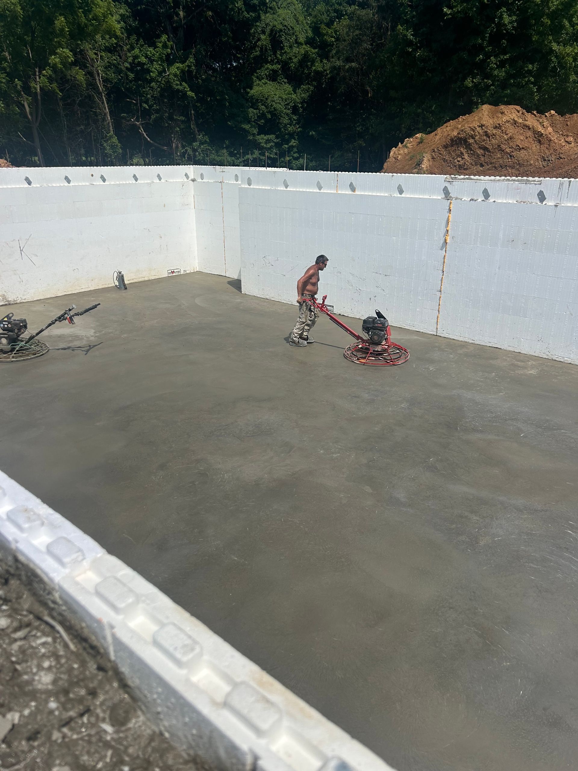A man is using a machine to level a concrete floor.