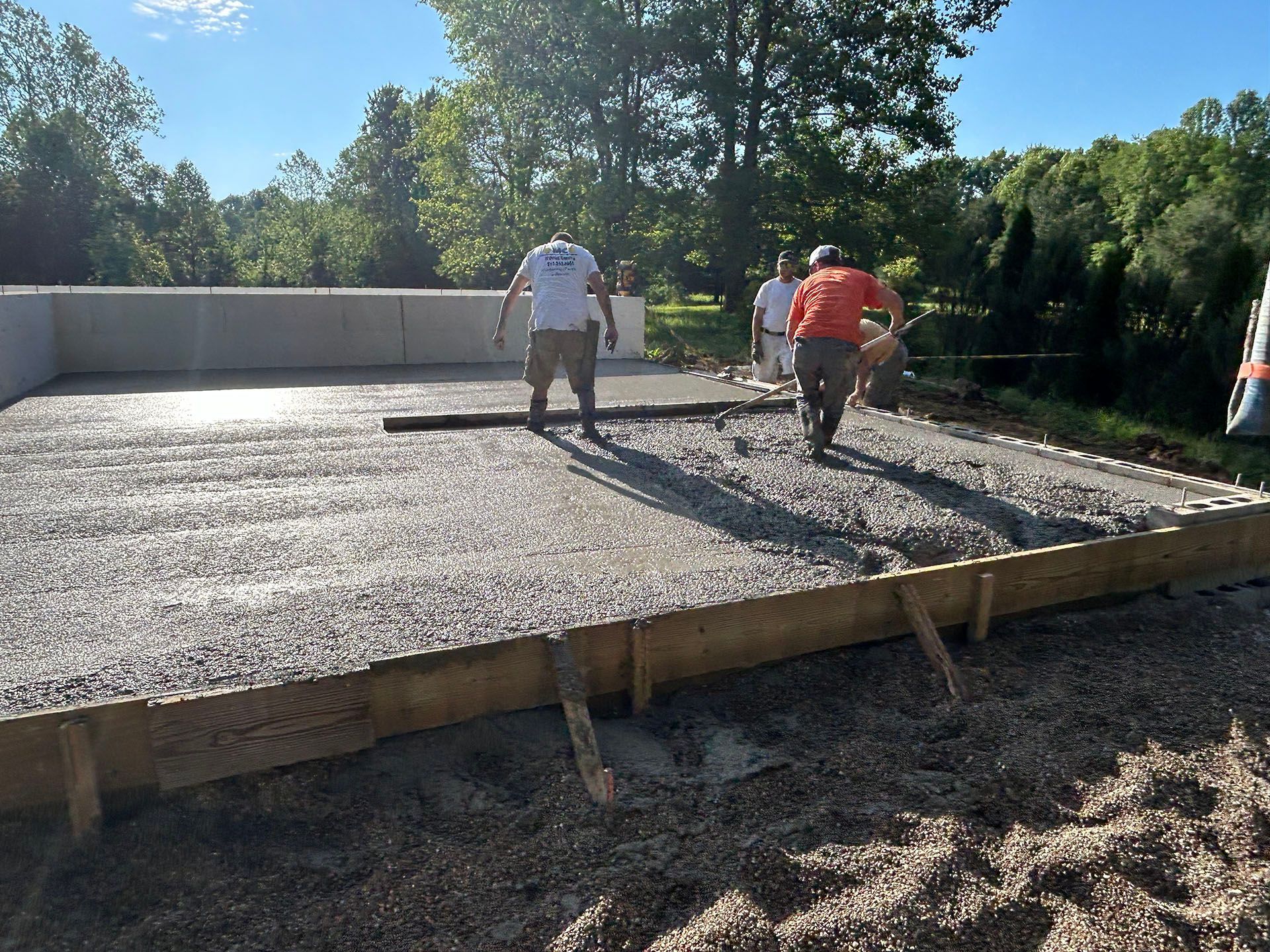 A group of men are working on a concrete floor.