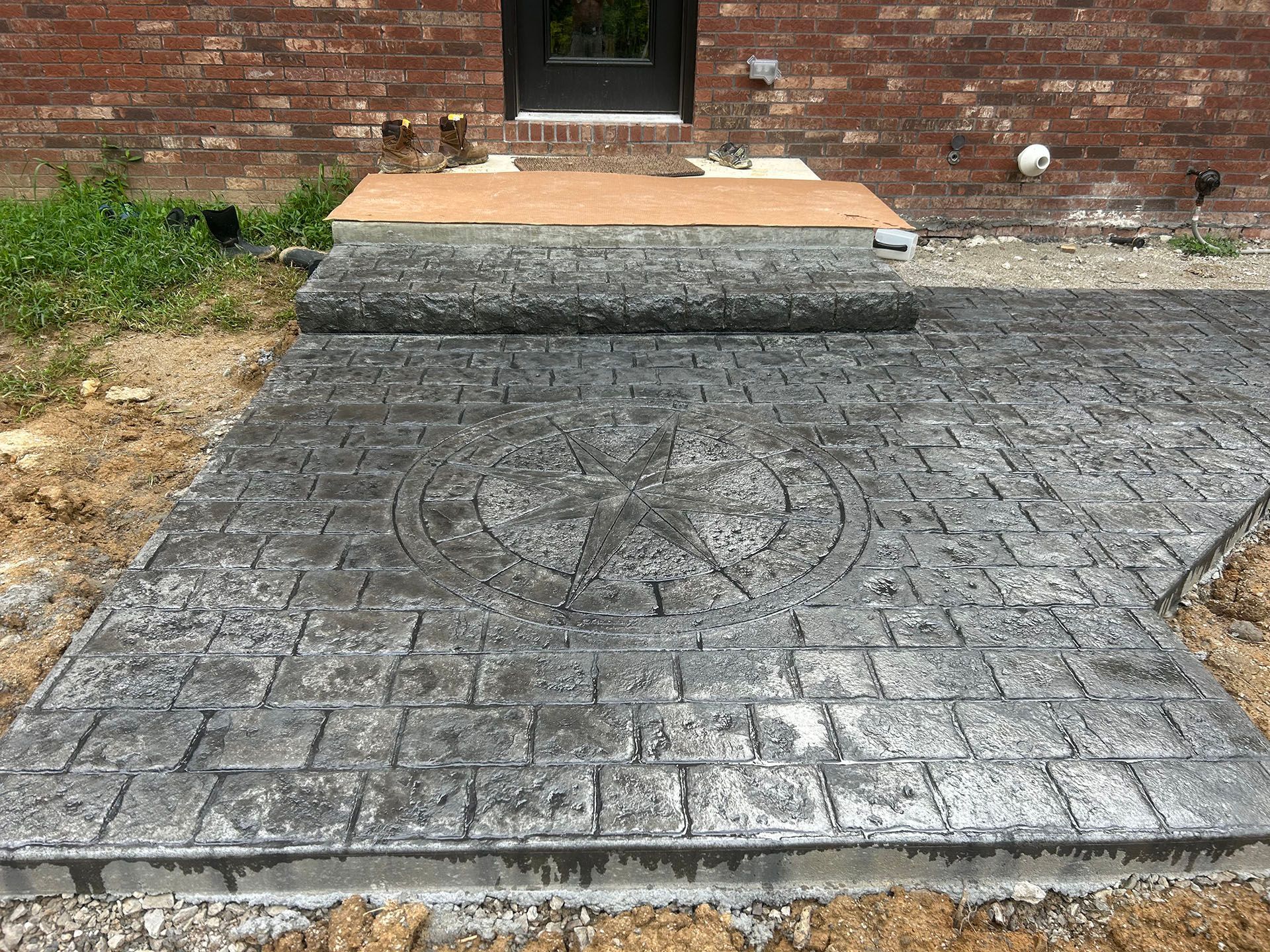 A concrete walkway is being built in front of a brick building.