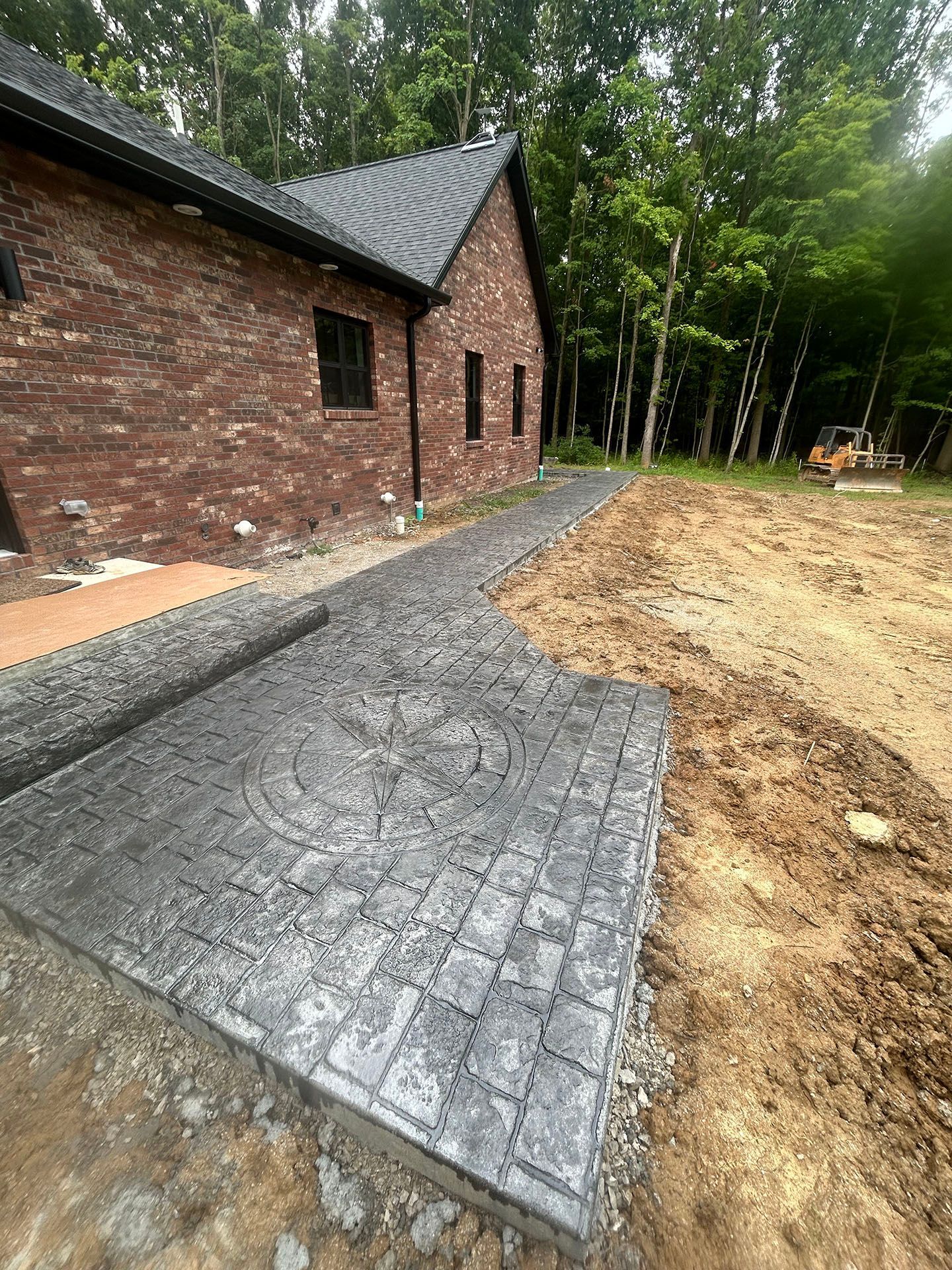 A brick house with a concrete walkway in front of it.
