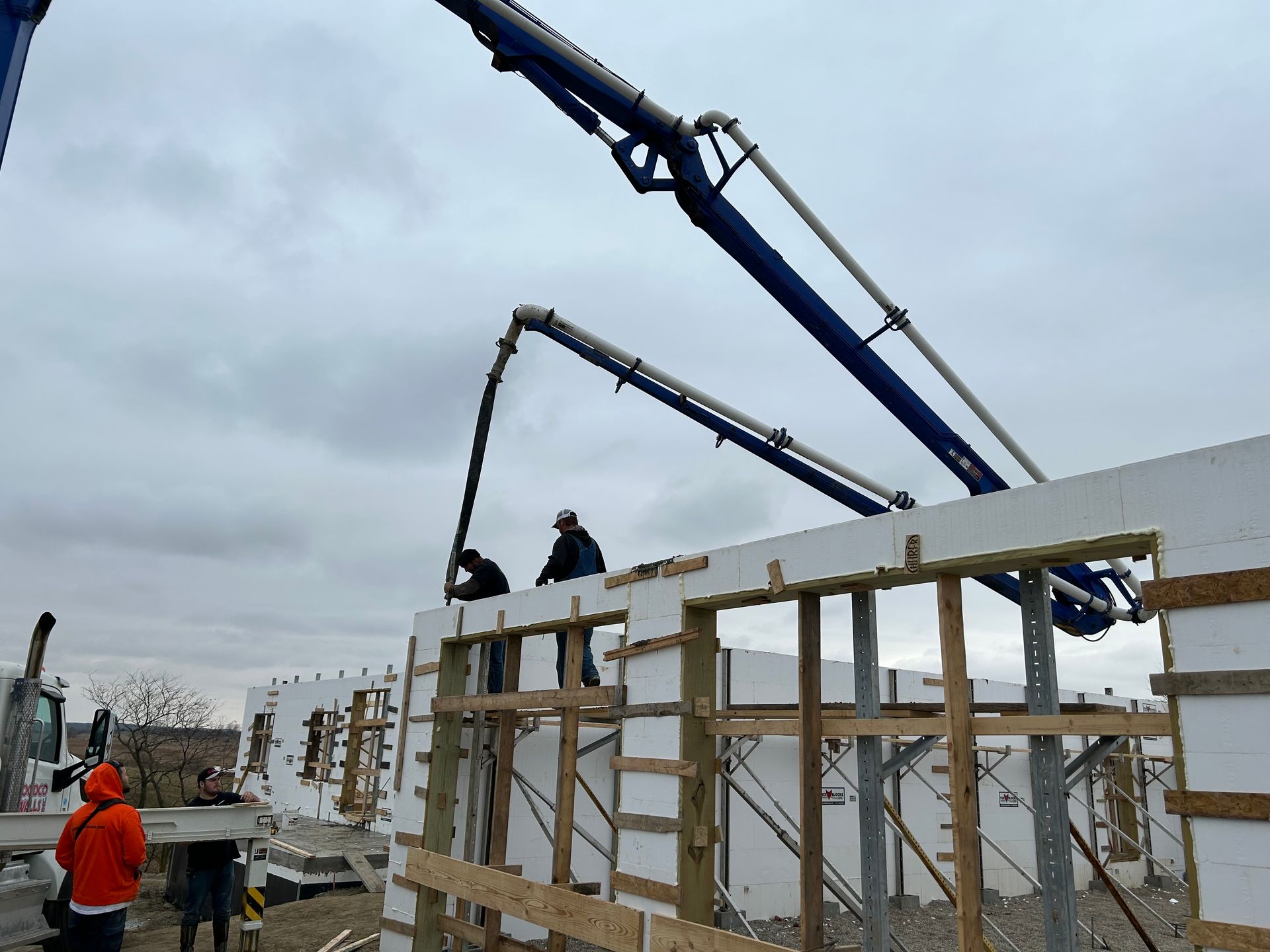A concrete pump is being used to pour concrete into a building